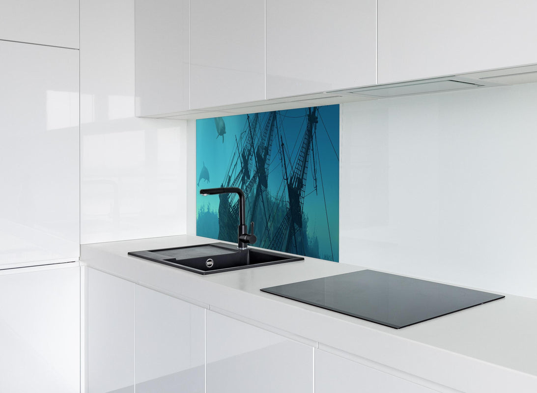 Spritzschutz -  mystisches Schiffswrack mit Delfinen hinter modernem schwarz-matten Spülbecken in weißer Hochglanz-Küche