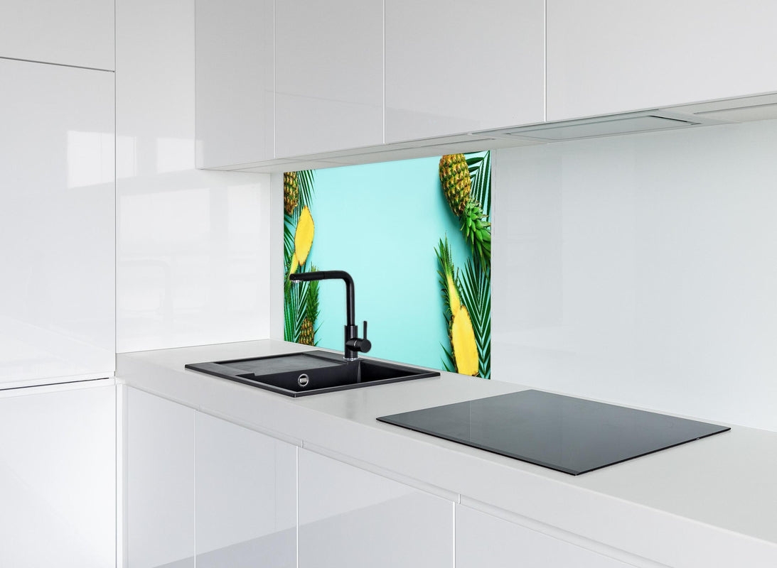 Spritzschutz - Ananas und tropische Palmenblätter hinter modernem schwarz-matten Spülbecken in weißer Hochglanz-Küche