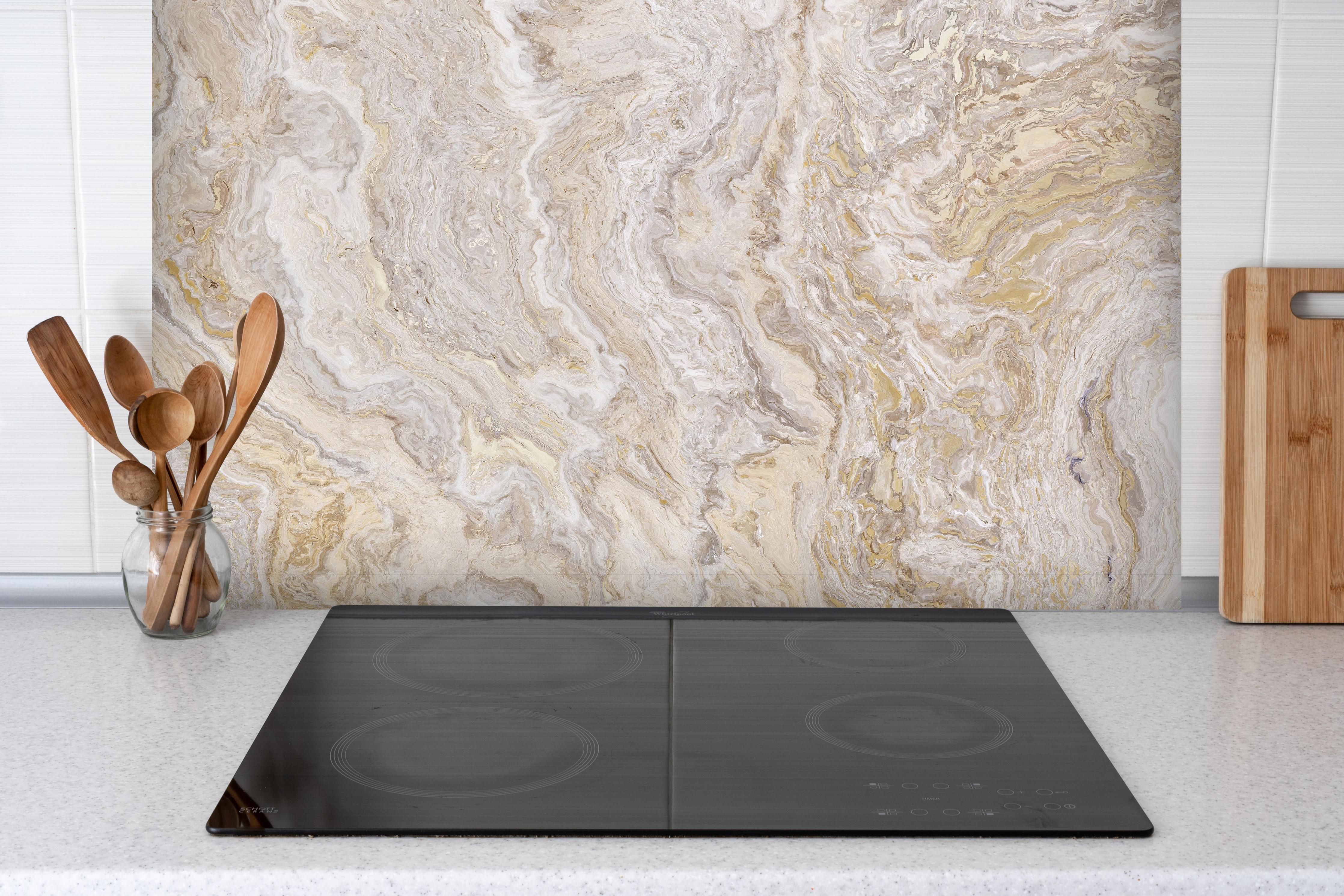Spritzschutz - Beiger Travertinmarmor hinter einem Cerankochfeld zwischen Holz-Kochutensilien
