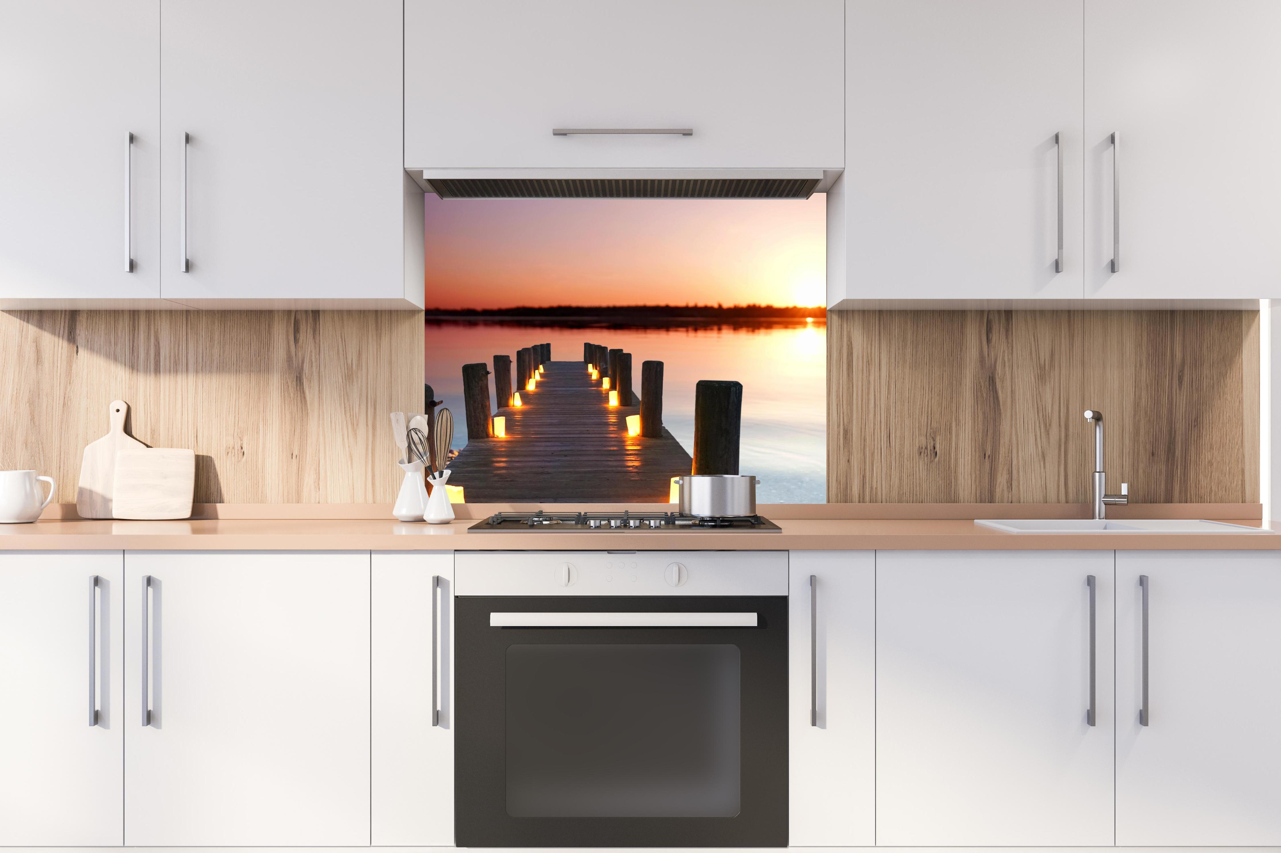Spritzschutz - Beleuchteter romantischer Steg am Strand hinter stilvollem Gasherd unter Dunstabzugshaube