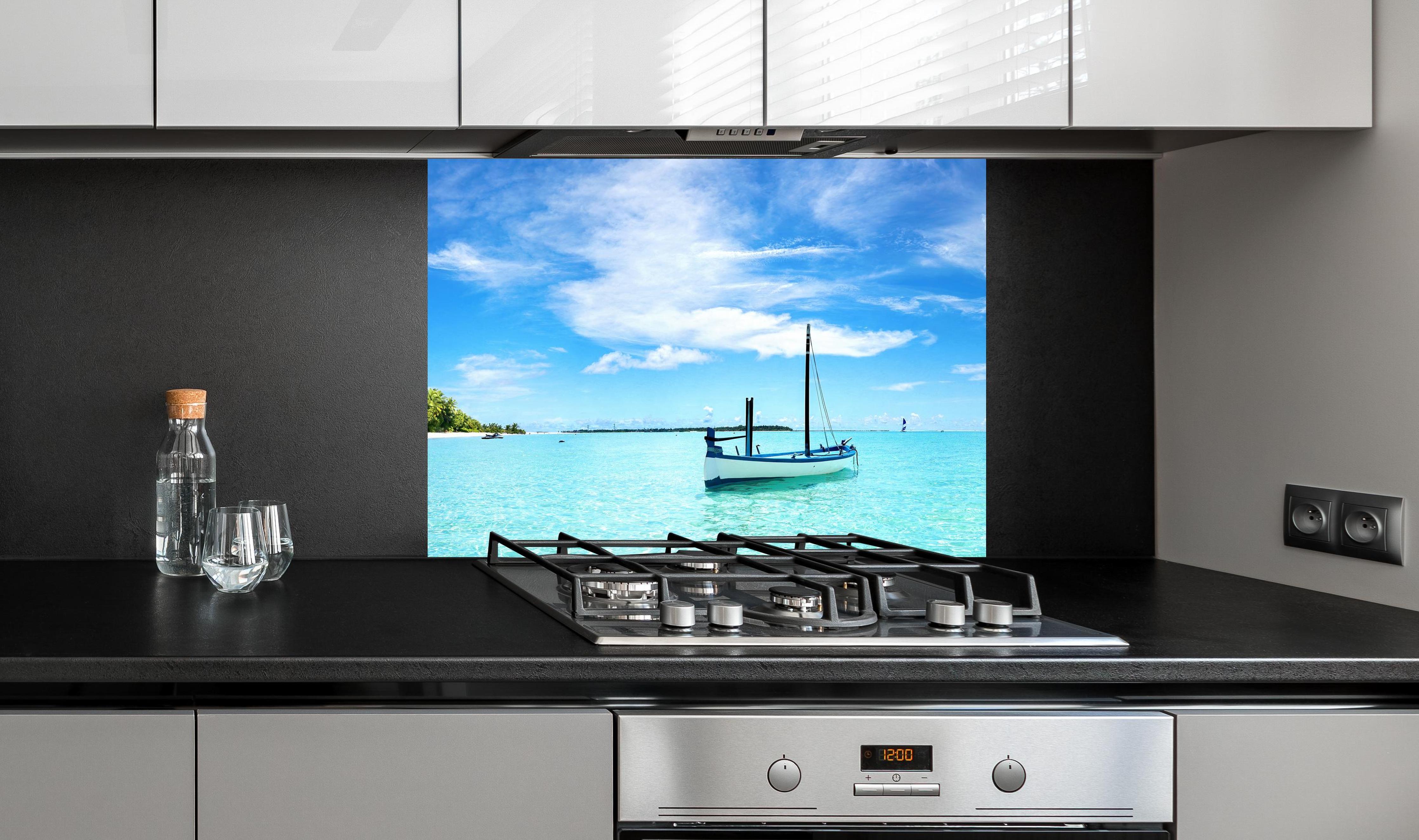 Spritzschutz - Boot im türkisfarbenen Meerwasser an edler Anthrazit-Wand hinter silbernem Gasherd