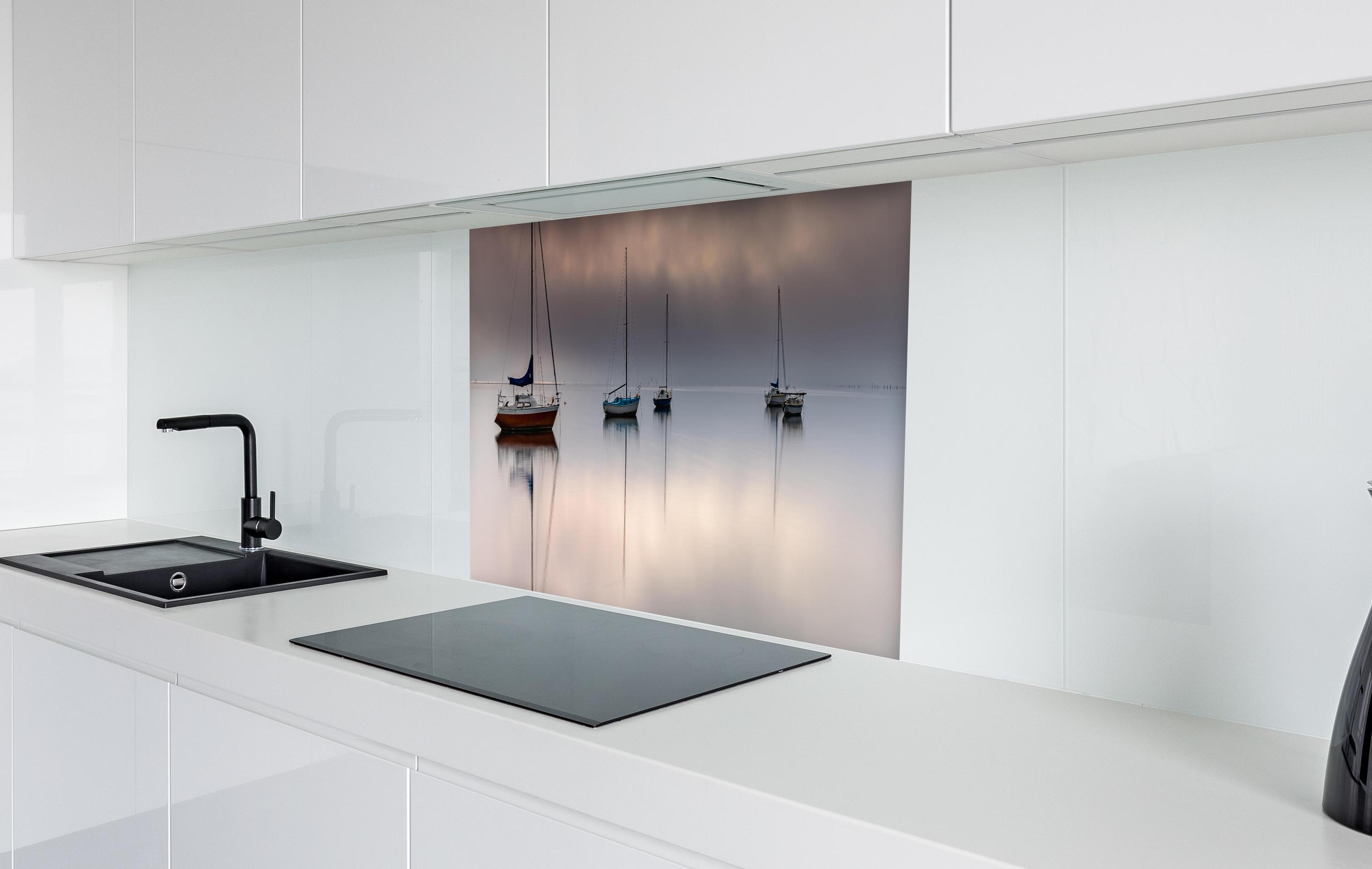 Spritzschutz - Boote auf nebeligem Meer  in weißer Hochglanz-Küche hinter einem Cerankochfeld