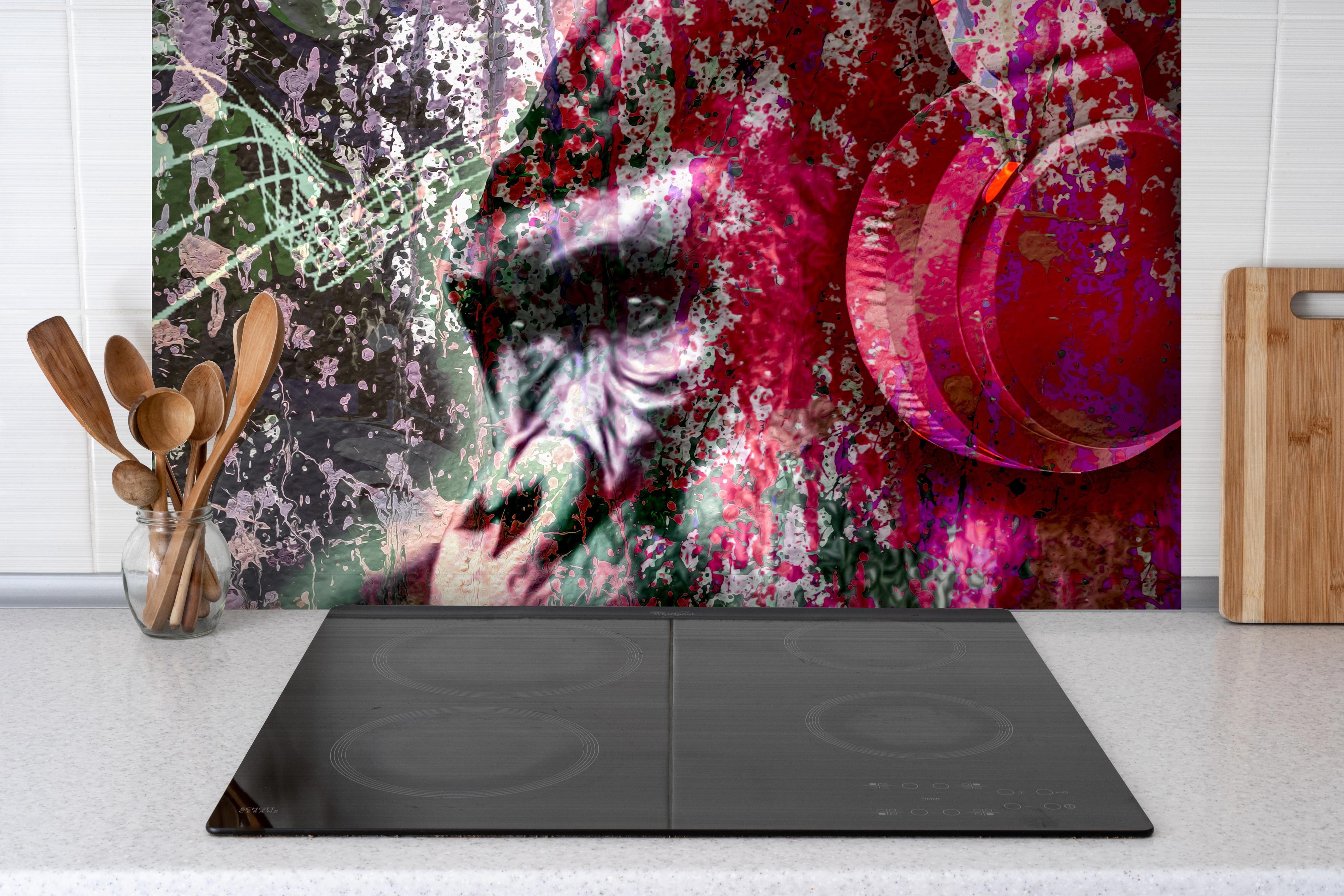 Spritzschutz - Bunter Affenkopf mit Musik-Elementen hinter einem Cerankochfeld zwischen Holz-Kochutensilien
