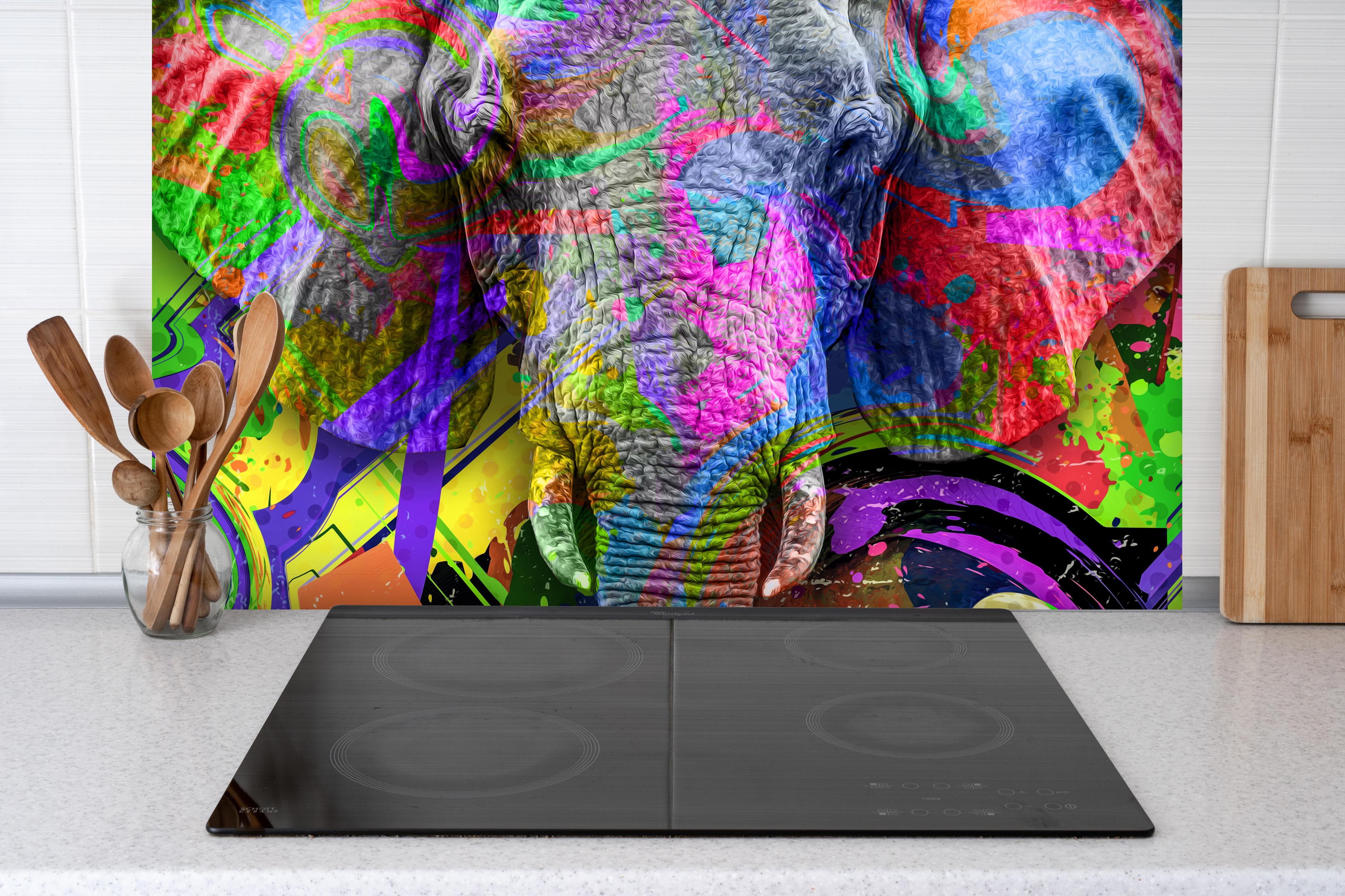 Spritzschutz - Bunter abstrakter Elefantenkopf hinter einem Cerankochfeld zwischen Holz-Kochutensilien
