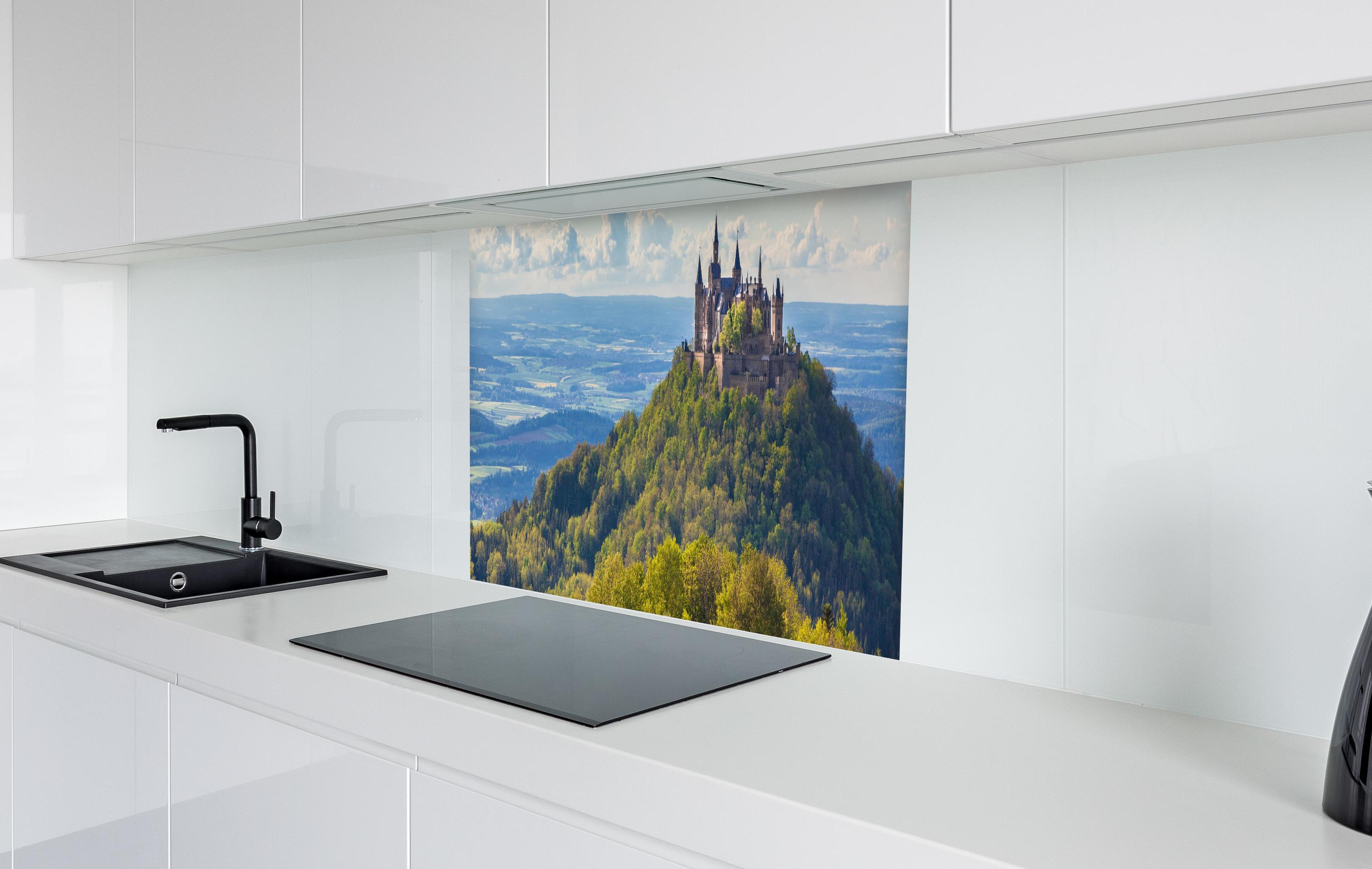 Spritzschutz - Burg Hohenzollern mit gelblichen Wald  in weißer Hochglanz-Küche hinter einem Cerankochfeld