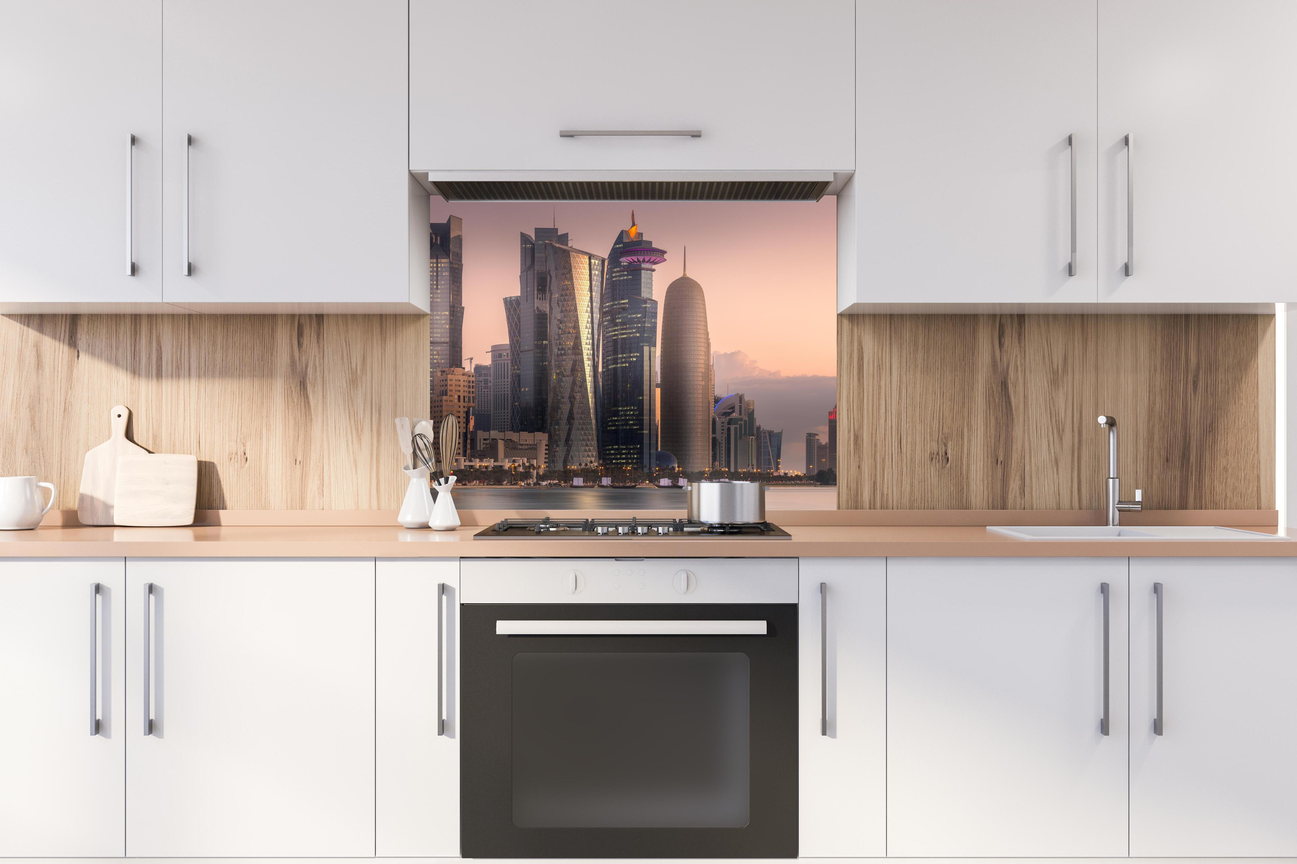 Spritzschutz - Die Skyline von West Bay und Doha City hinter stilvollem Gasherd unter Dunstabzugshaube
