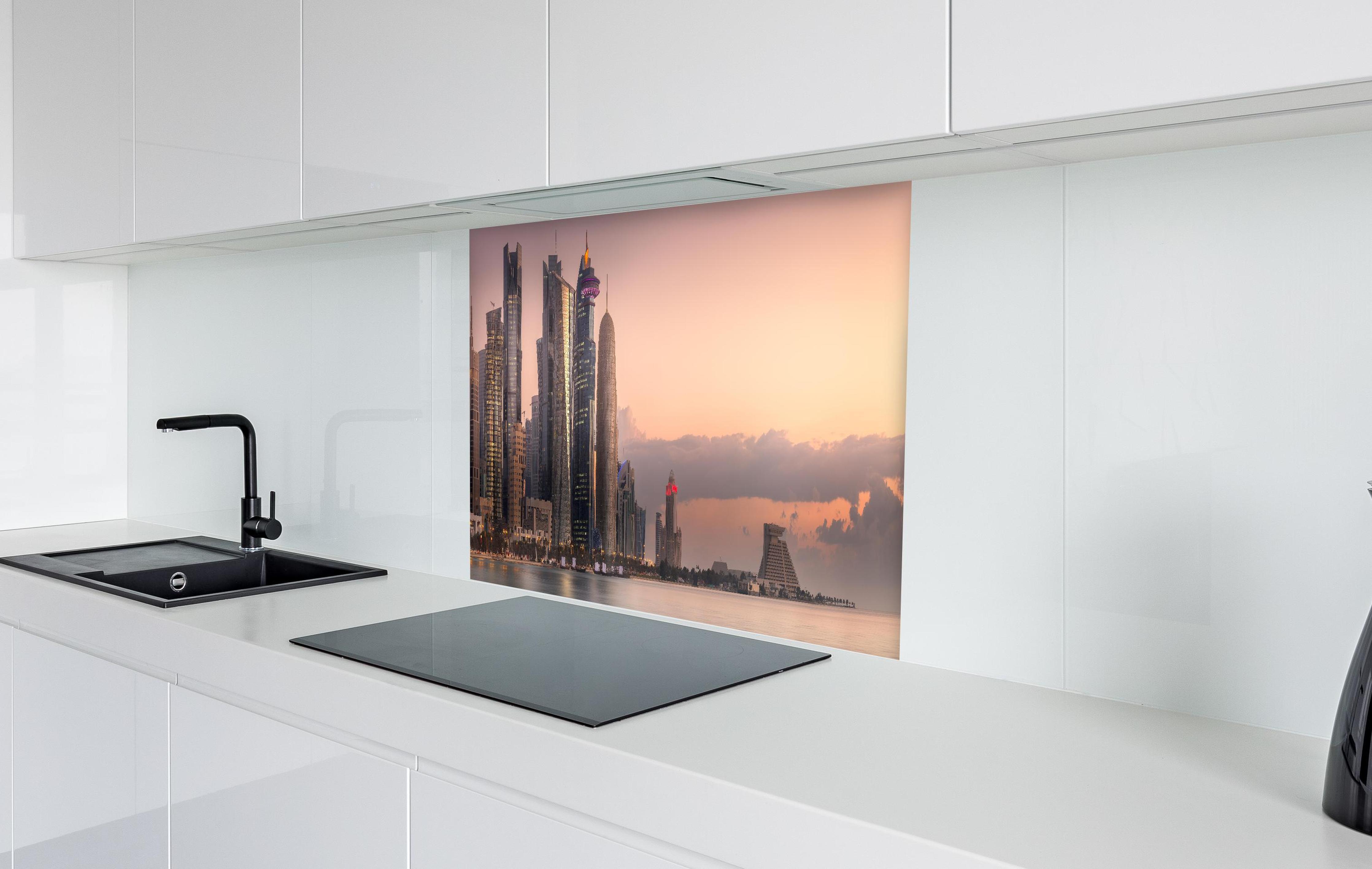 Spritzschutz - Die Skyline von West Bay und Doha City  in weißer Hochglanz-Küche hinter einem Cerankochfeld