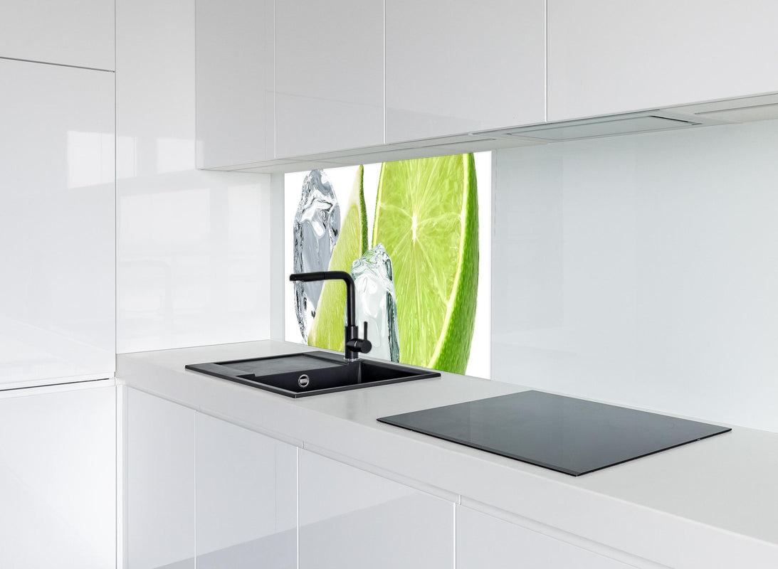 Spritzschutz - Eiswürfel mit saftiger Limette hinter modernem schwarz-matten Spülbecken in weißer Hochglanz-Küche