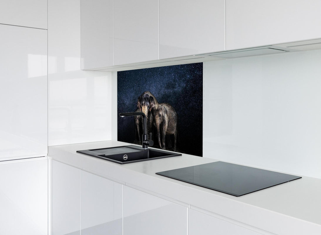 Spritzschutz - Elefantenfamilie zwischen den Sternen hinter modernem schwarz-matten Spülbecken in weißer Hochglanz-Küche