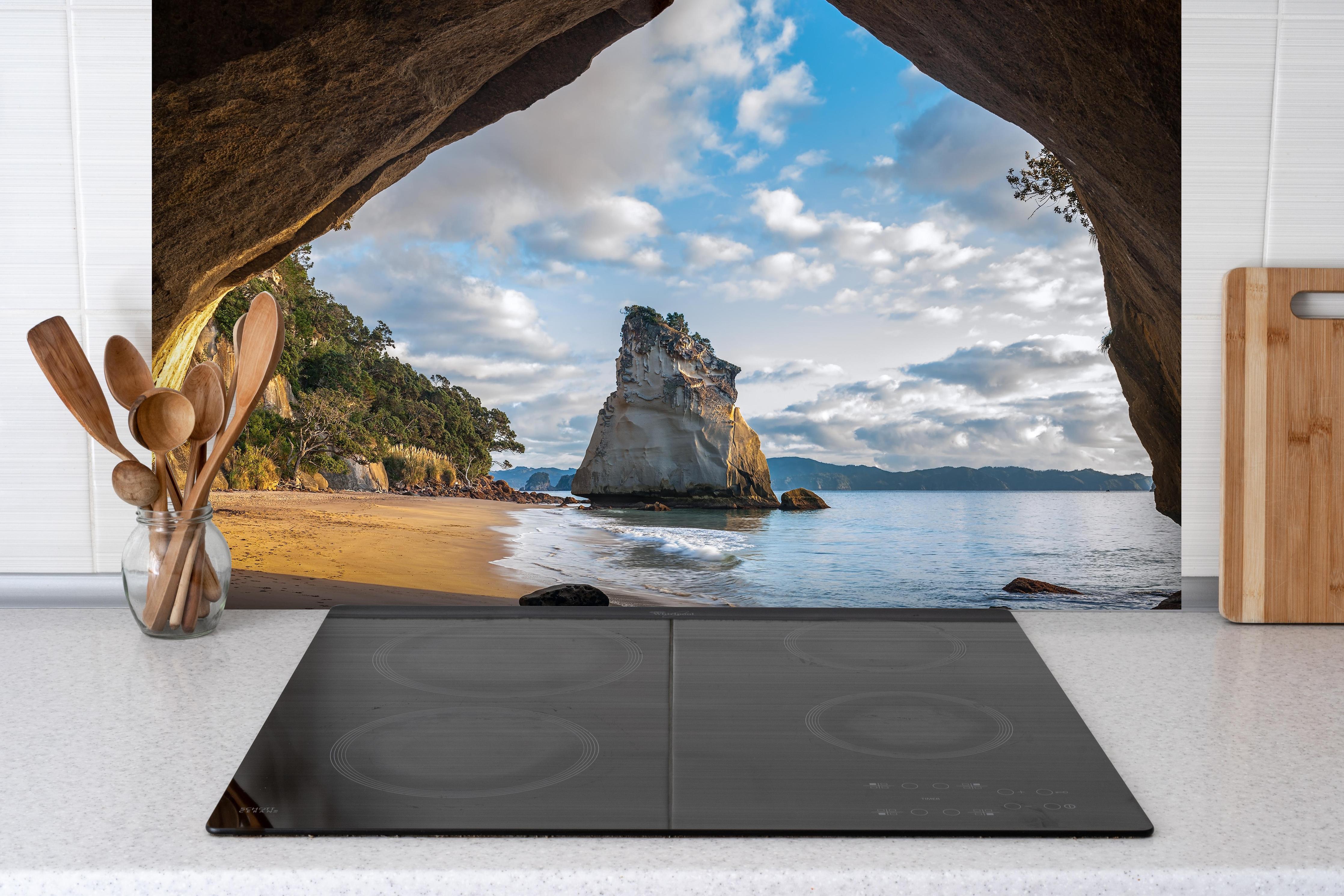 Spritzschutz - Erstaunlicher Felstunnel in Neuseeland hinter einem Cerankochfeld zwischen Holz-Kochutensilien
