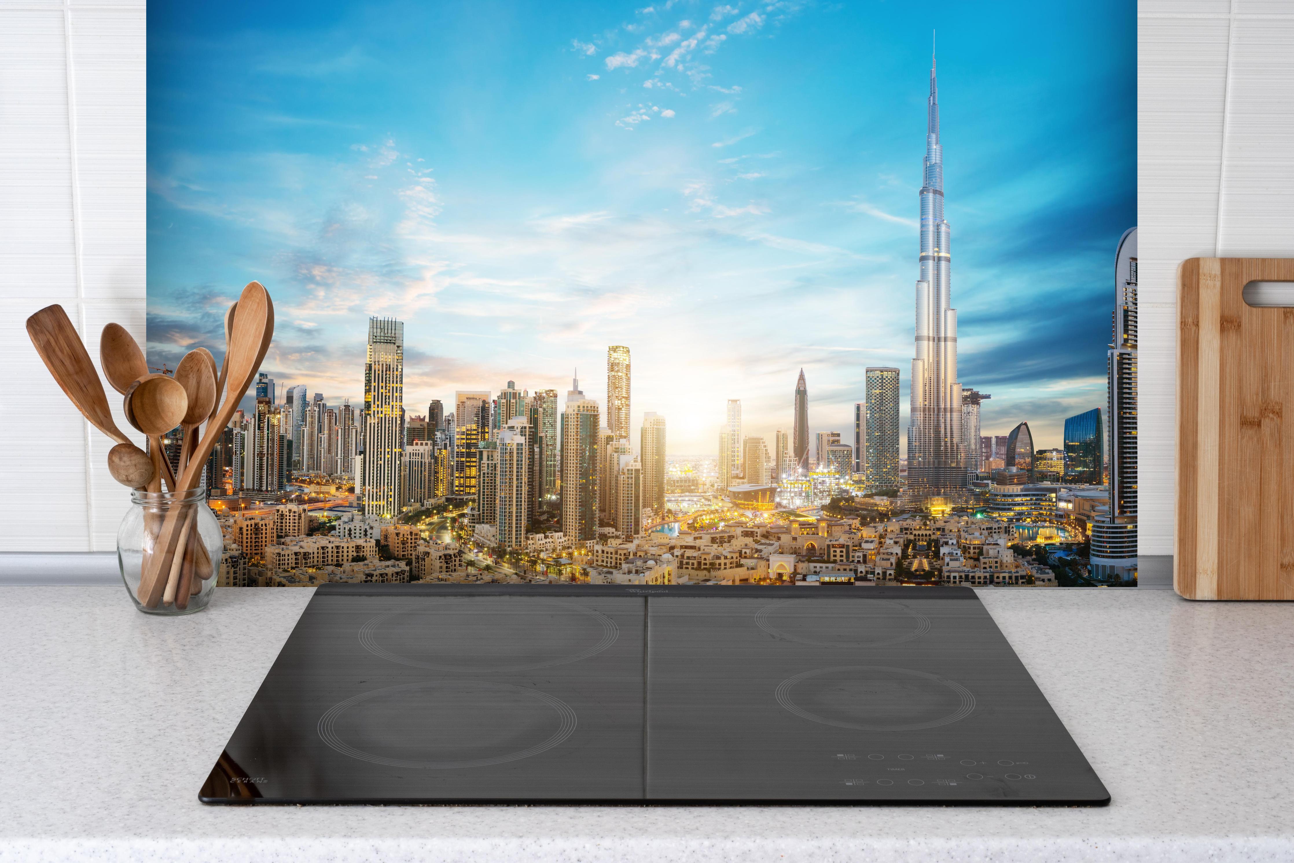 Spritzschutz - Erstaunlicher Panoramablick auf Dubai hinter einem Cerankochfeld zwischen Holz-Kochutensilien
