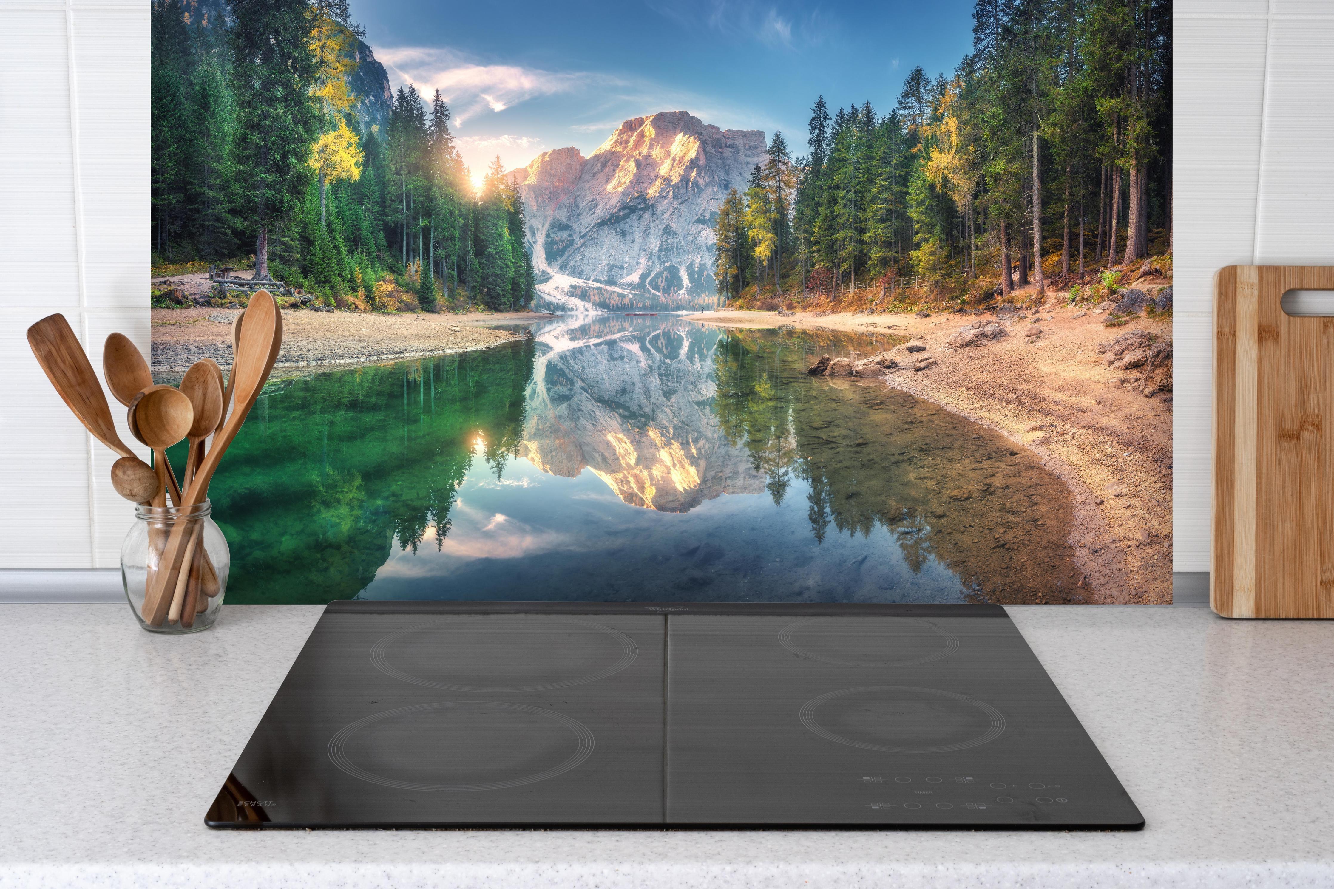 Spritzschutz - Erstaunlicher Pragser Wildsee bei Sonnenaufgang hinter einem Cerankochfeld zwischen Holz-Kochutensilien
