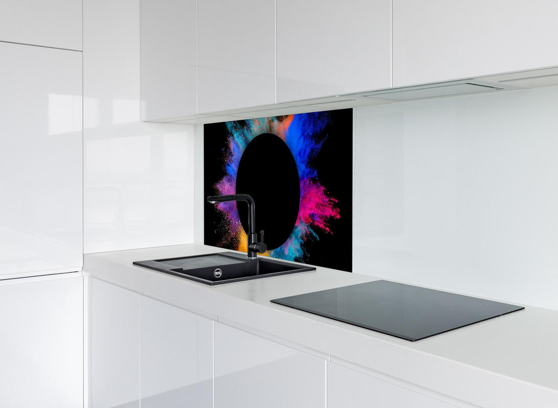Spritzschutz - Explosion von farbigem Pulver mit schwarzem Kreis hinter modernem schwarz-matten Spülbecken in weißer Hochglanz-Küche