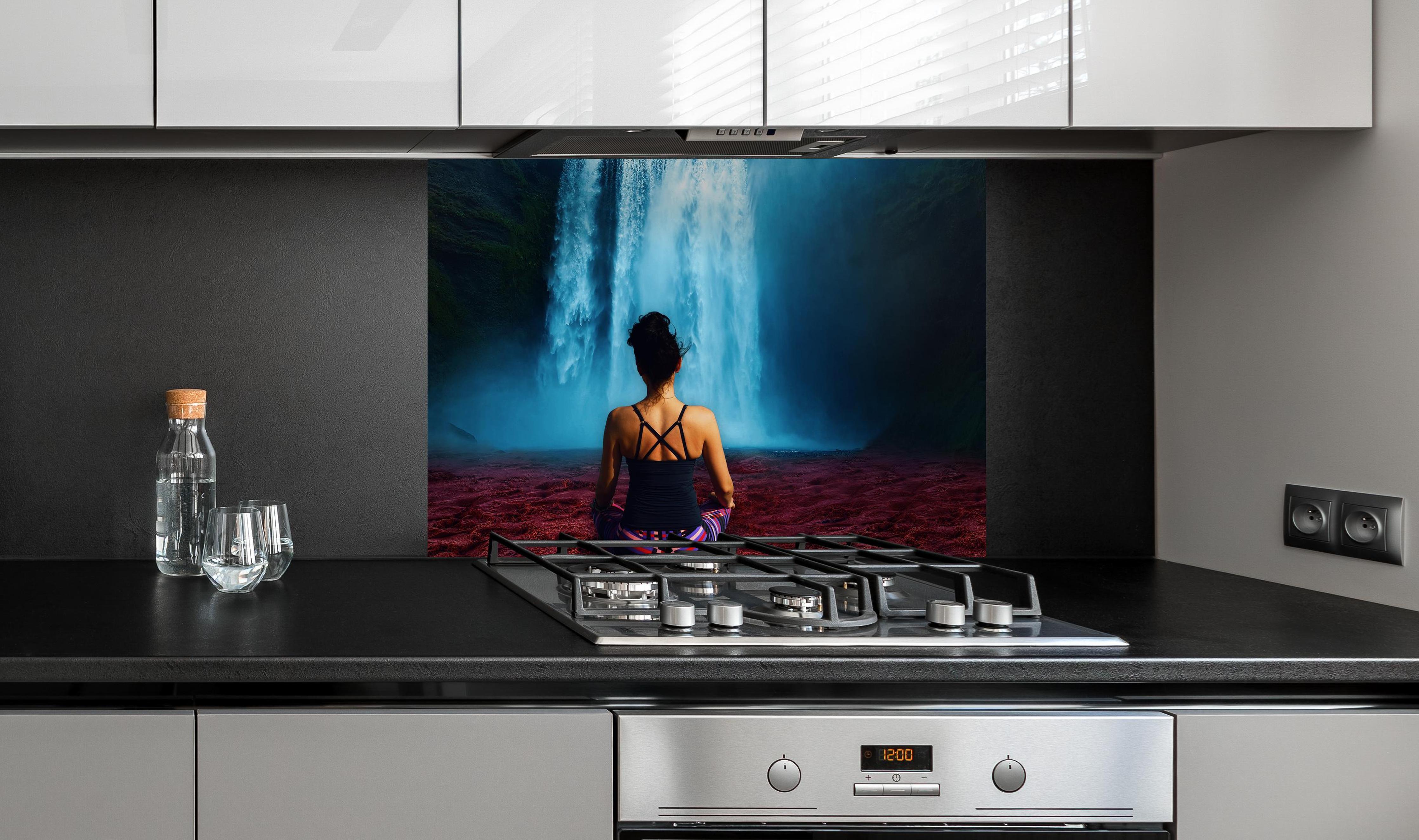 Spritzschutz - Frau meditierend vor traumhaften Wasserfall an edler Anthrazit-Wand hinter silbernem Gasherd