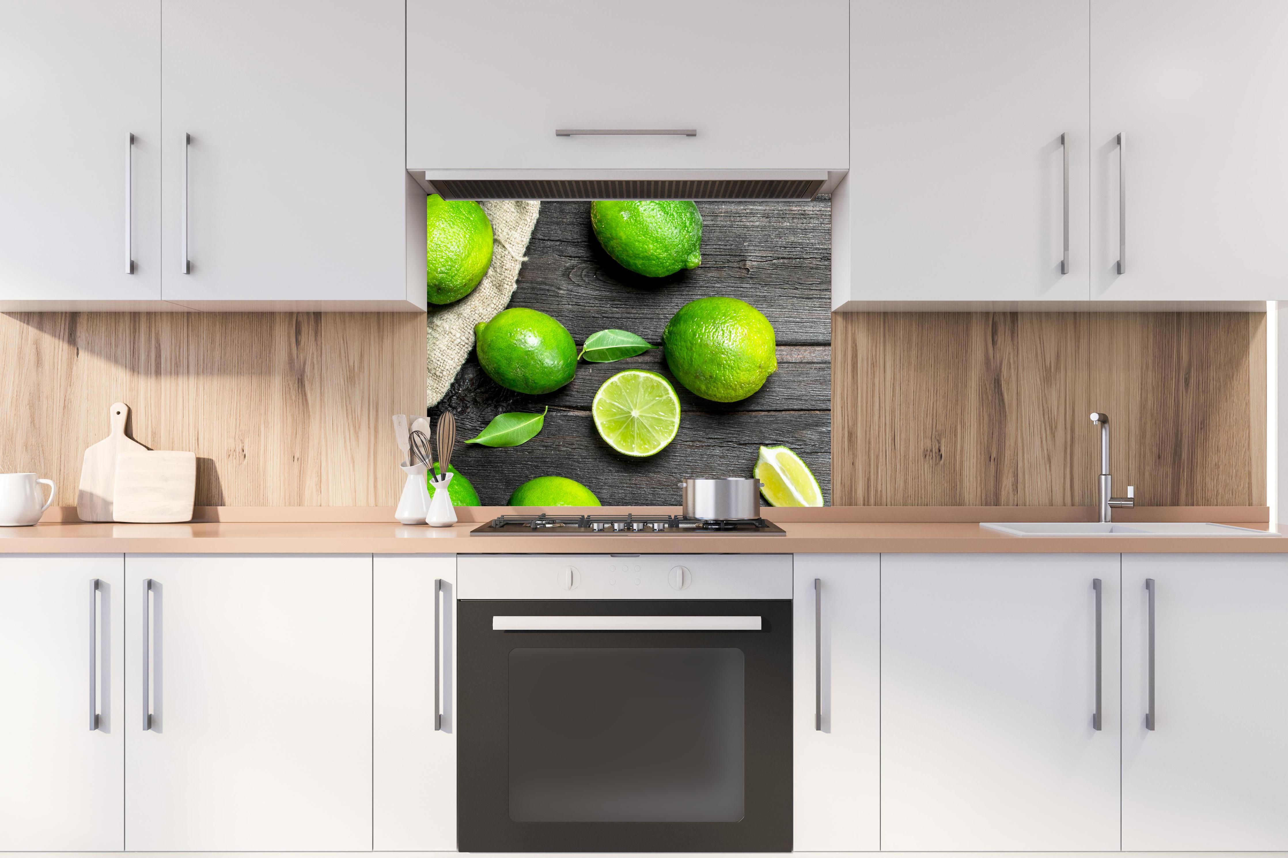 Spritzschutz - Frisch geerntete Limetten hinter stilvollem Gasherd unter Dunstabzugshaube