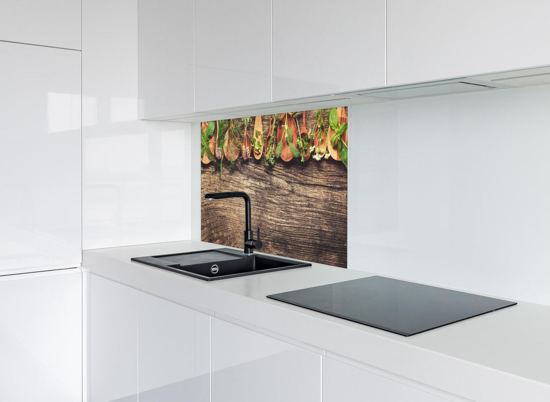 Spritzschutz - Frische Kräuter auf Holzplatte hinter modernem schwarz-matten Spülbecken in weißer Hochglanz-Küche