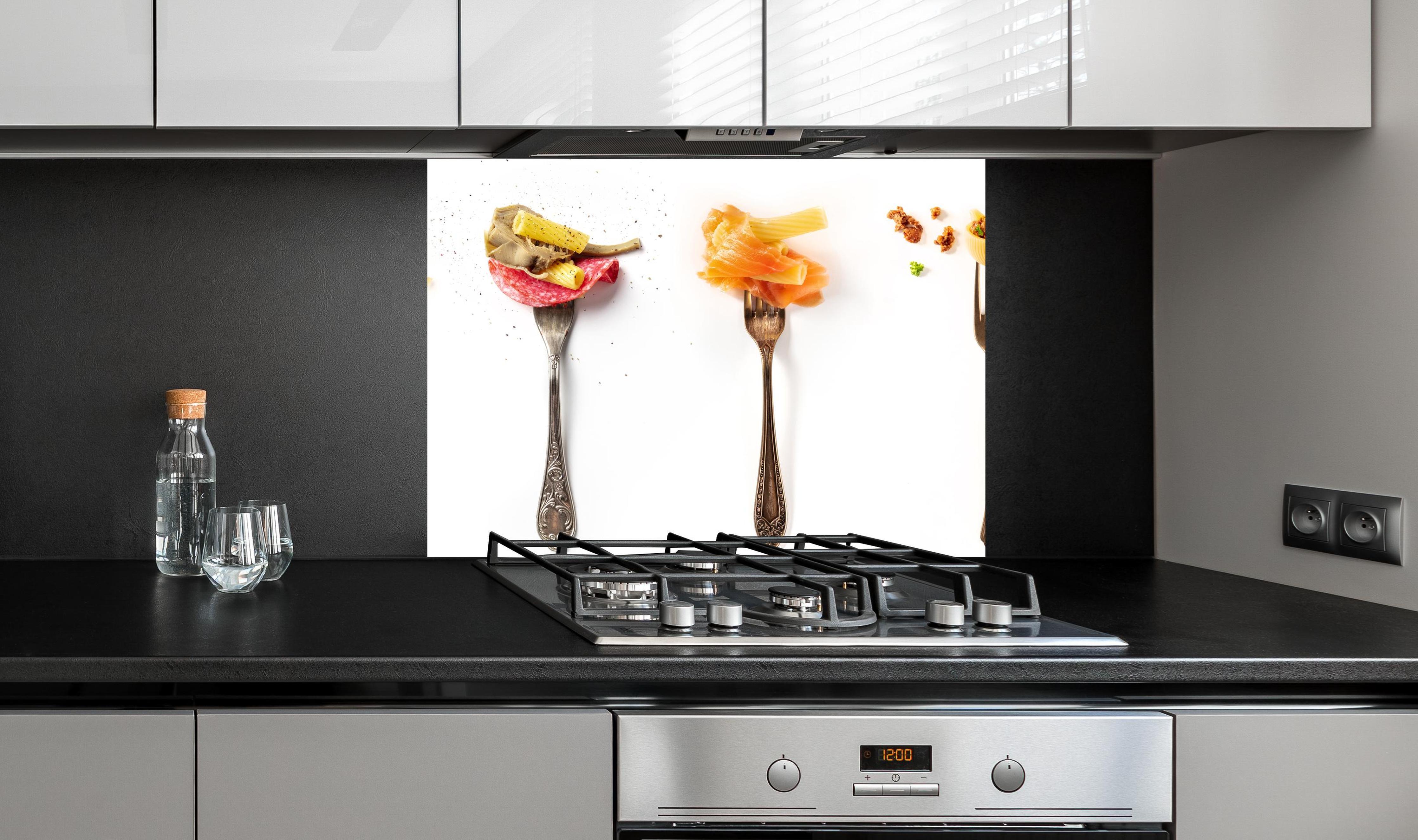 Spritzschutz - Gabeln mit Italienischer Pasta Essen an edler Anthrazit-Wand hinter silbernem Gasherd
