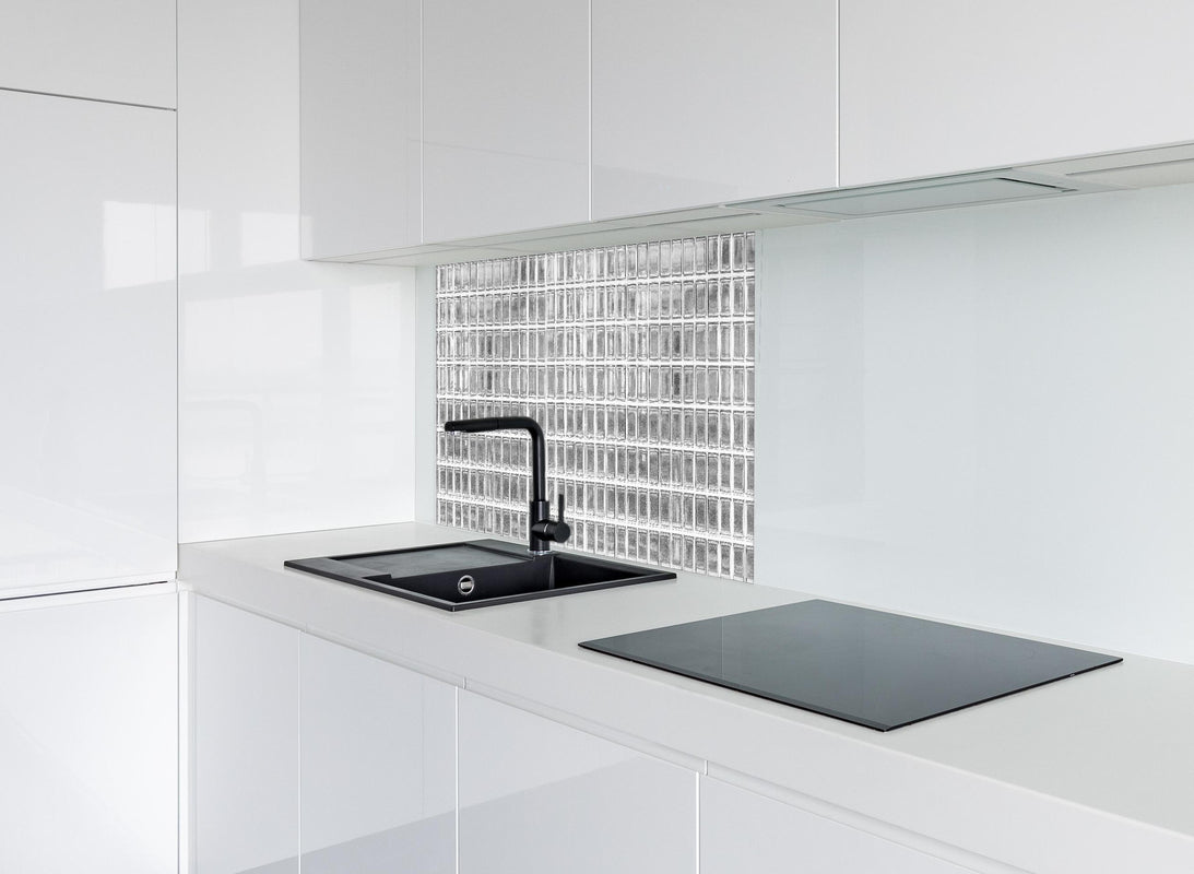 Spritzschutz - Glaswand hinter modernem schwarz-matten Spülbecken in weißer Hochglanz-Küche
