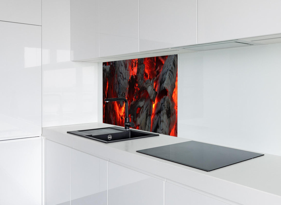 Spritzschutz - Glühendes Feuer - Nahaufnahme hinter modernem schwarz-matten Spülbecken in weißer Hochglanz-Küche