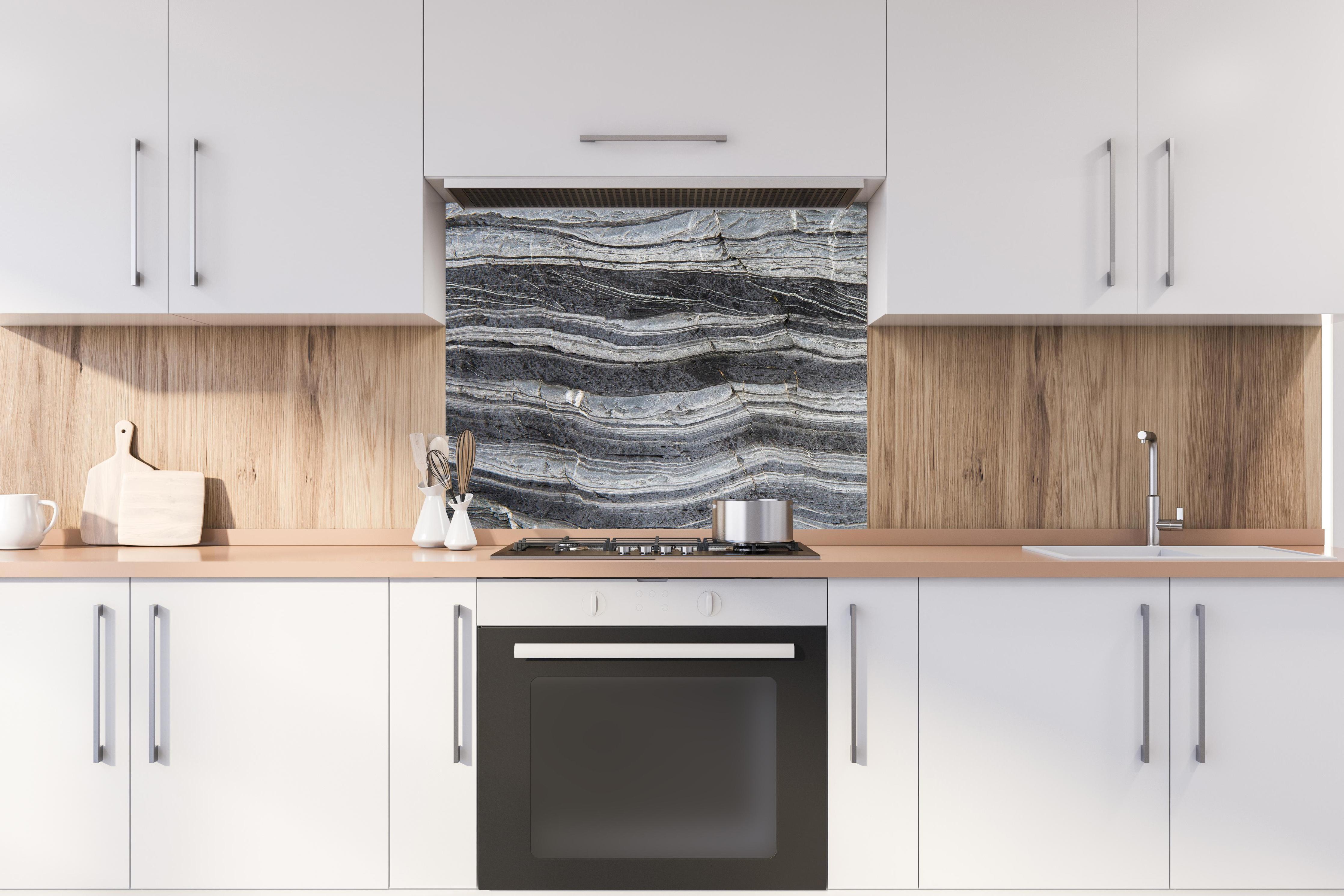Spritzschutz - Gräulicher rissiger Schiefer hinter stilvollem Gasherd unter Dunstabzugshaube