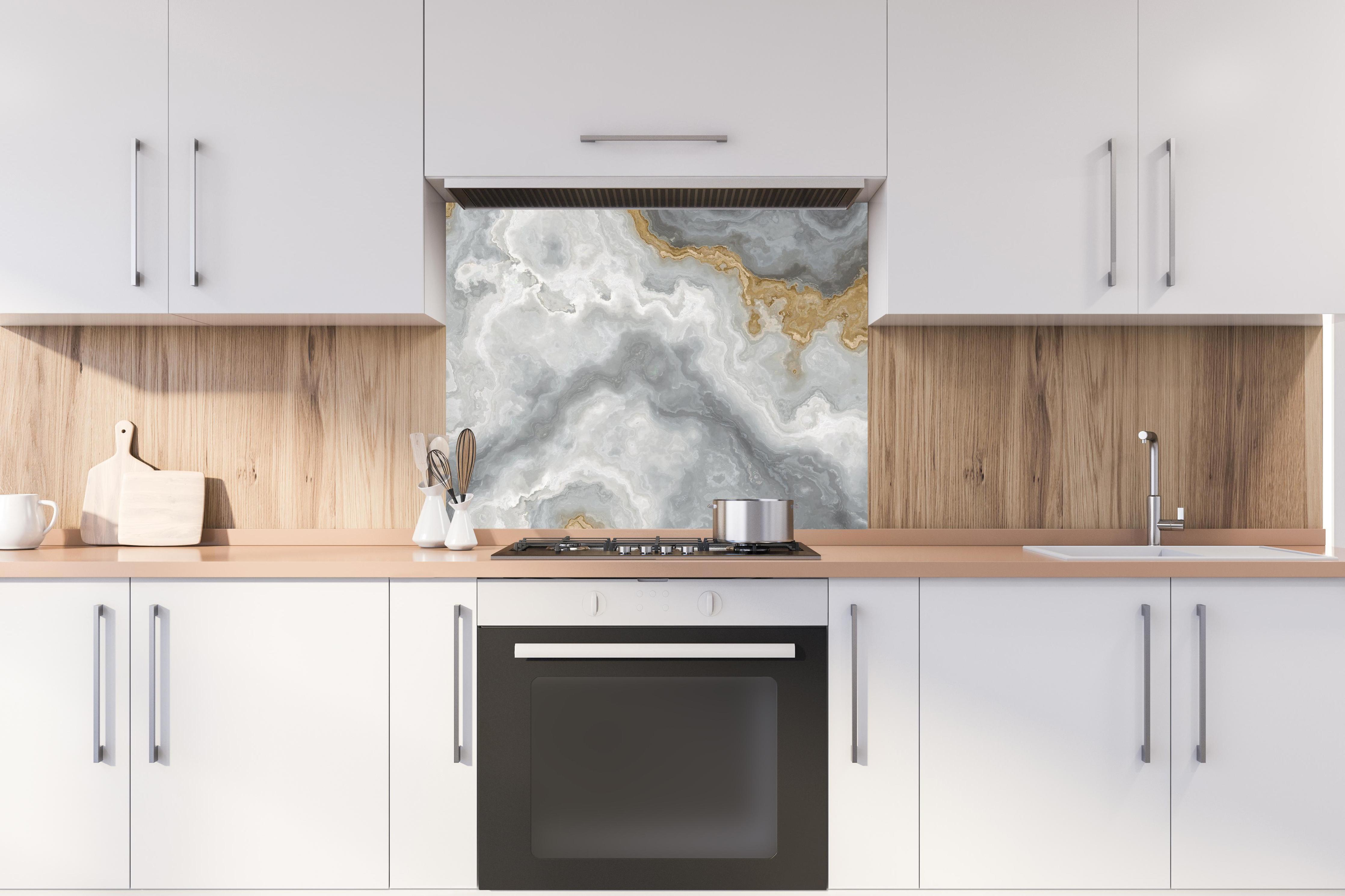 Spritzschutz - Grau-weißes Marmormuster hinter stilvollem Gasherd unter Dunstabzugshaube