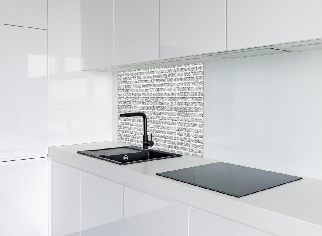 Spritzschutz - Graue alte Ziegelwand hinter modernem schwarz-matten Spülbecken in weißer Hochglanz-Küche