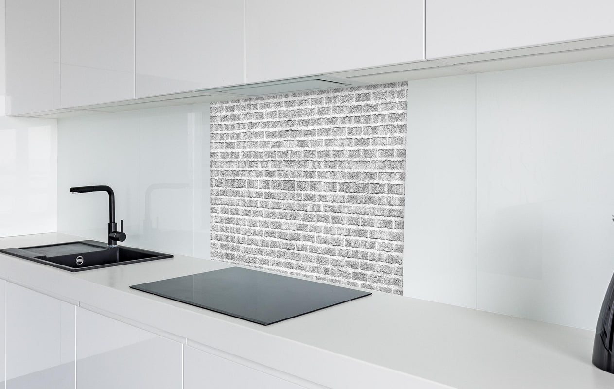 Spritzschutz - Graue alte Ziegelwand  in weißer Hochglanz-Küche hinter einem Cerankochfeld