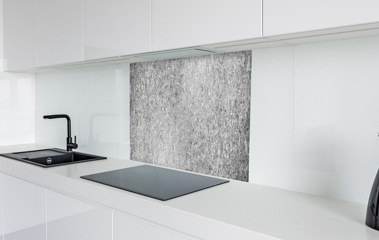 Spritzschutz - Graue schäbige Betonwand  in weißer Hochglanz-Küche hinter einem Cerankochfeld