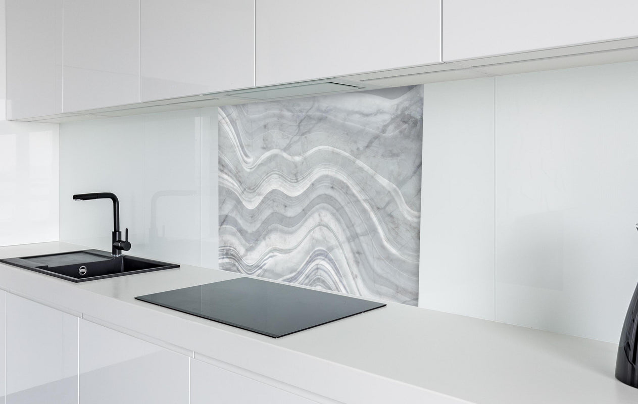 Spritzschutz - Graue wellenförmige Marmor Textur  in weißer Hochglanz-Küche hinter einem Cerankochfeld