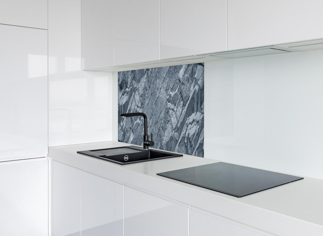 Spritzschutz - Grauer Fels hinter modernem schwarz-matten Spülbecken in weißer Hochglanz-Küche