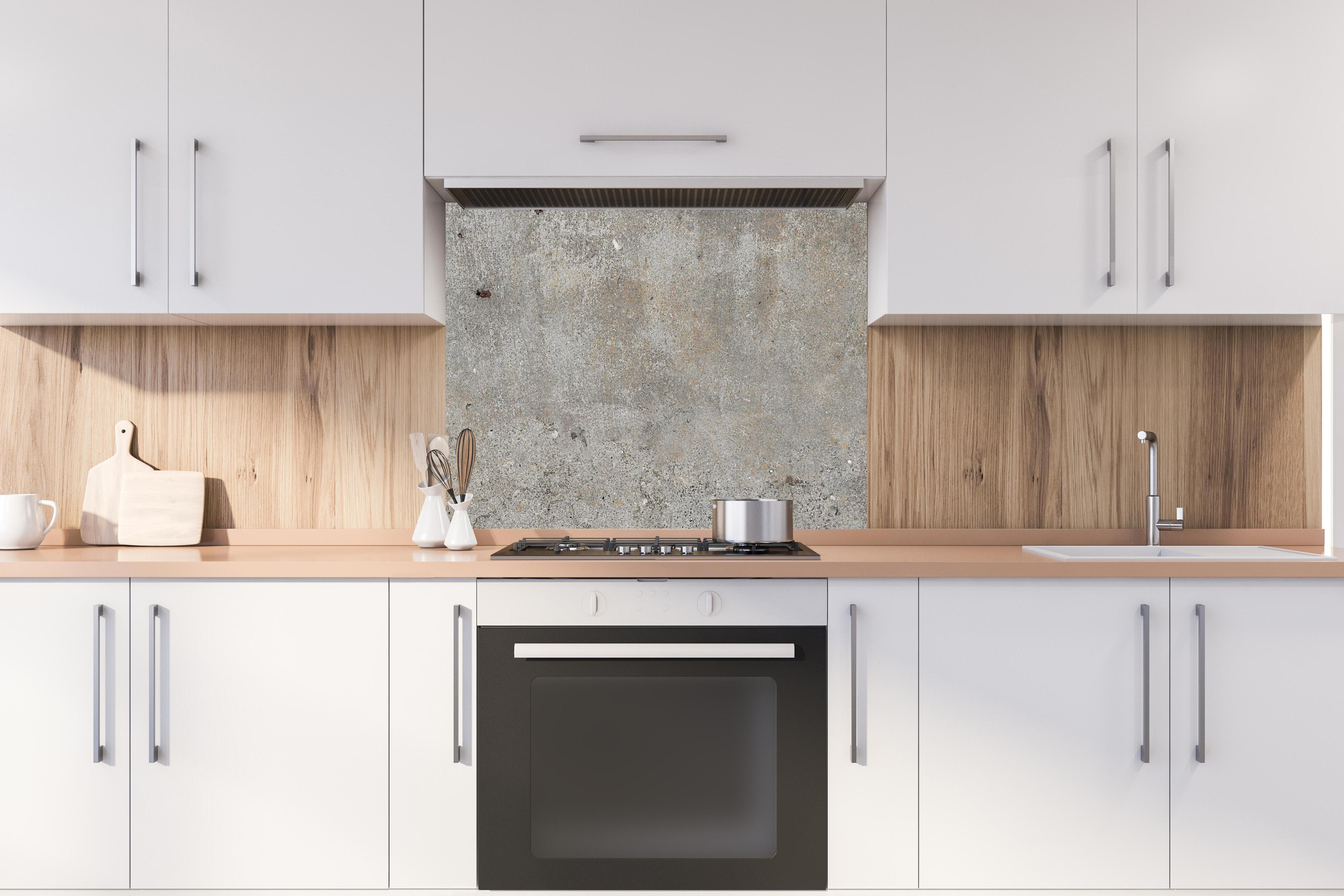 Spritzschutz - Grauer rustikaler Beton hinter stilvollem Gasherd unter Dunstabzugshaube