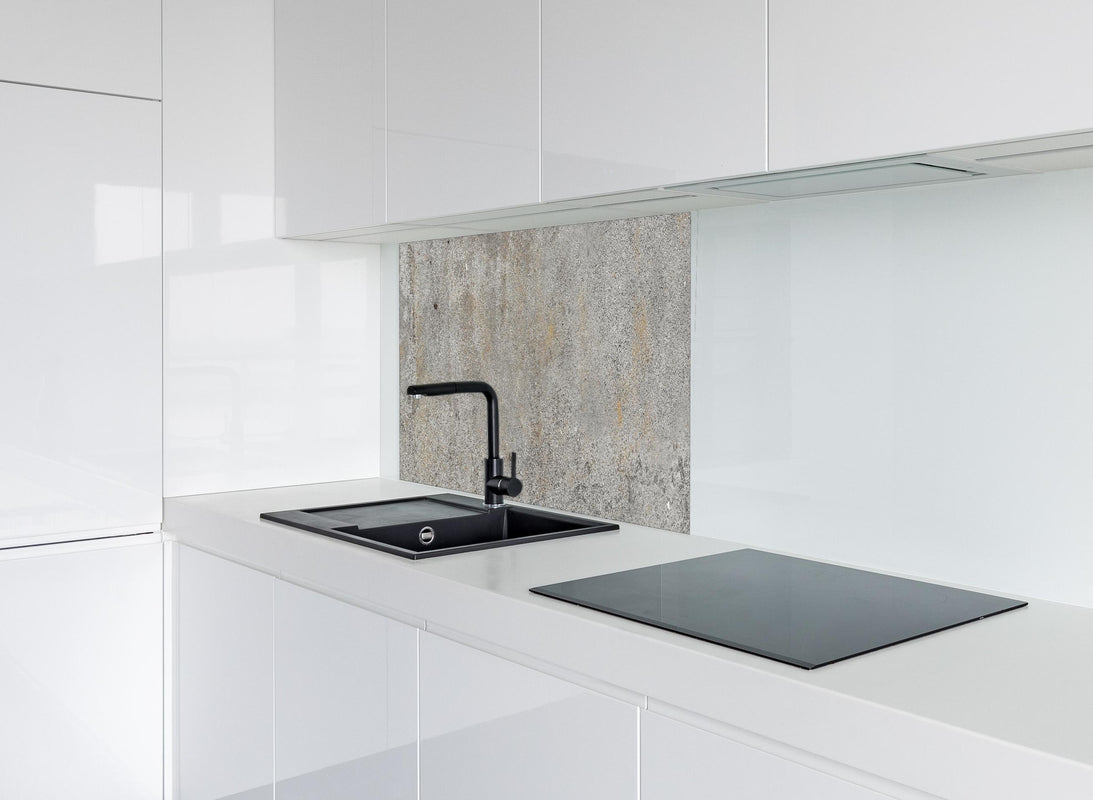 Spritzschutz - Grauer rustikaler Beton hinter modernem schwarz-matten Spülbecken in weißer Hochglanz-Küche