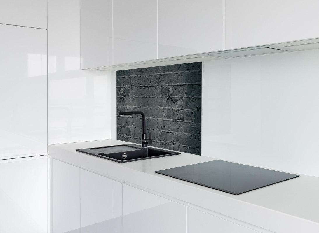 Spritzschutz - Graues ausgefallenes Mauerwerk hinter modernem schwarz-matten Spülbecken in weißer Hochglanz-Küche