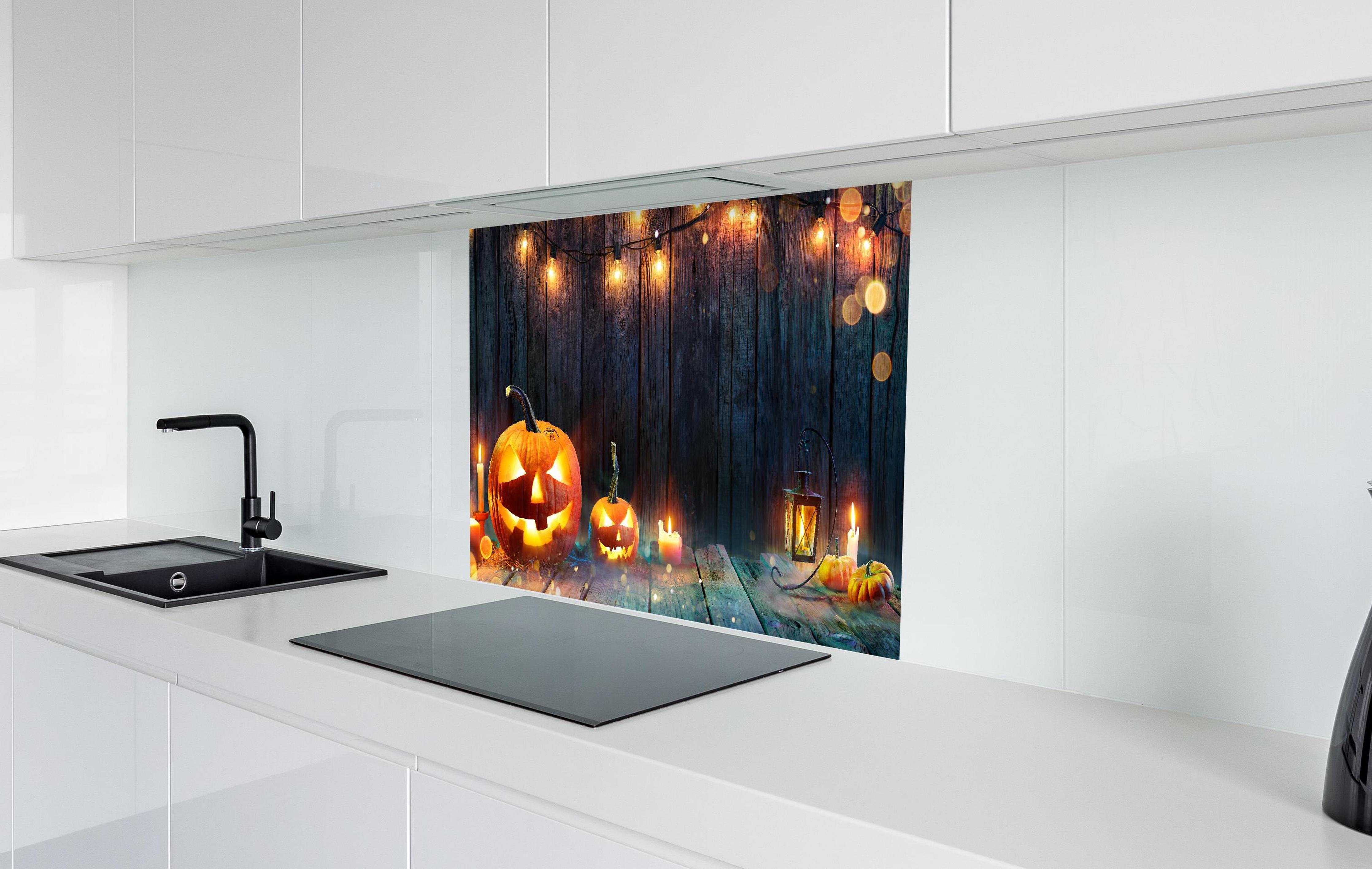 Spritzschutz - Halloween - Kerzen und Lichterketten  in weißer Hochglanz-Küche hinter einem Cerankochfeld