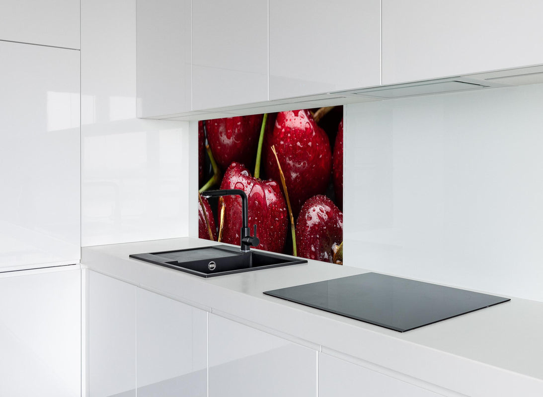 Spritzschutz - Kirschen mit Wasserperlen hinter modernem schwarz-matten Spülbecken in weißer Hochglanz-Küche