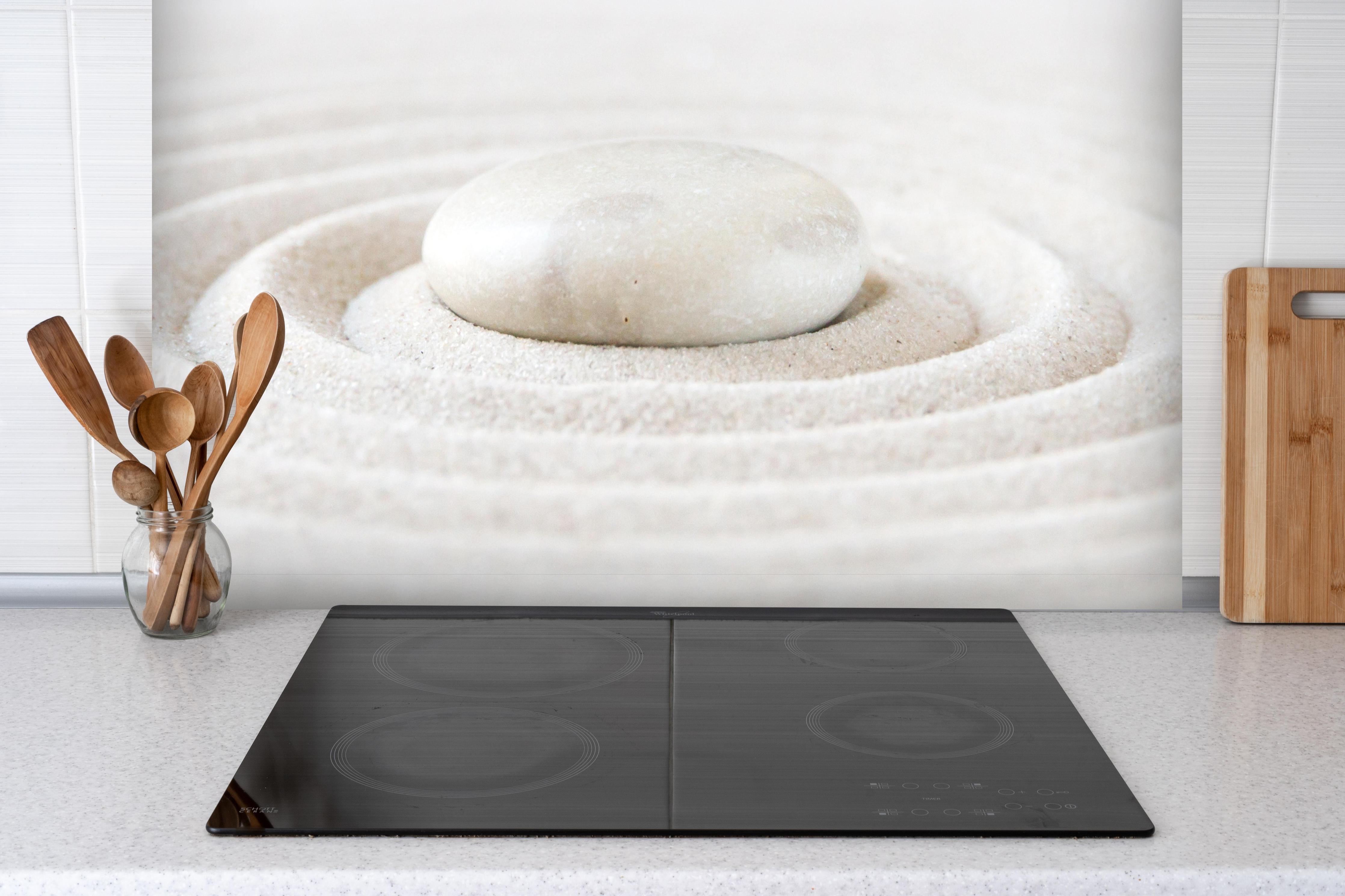 Spritzschutz - Kleiner Zen Garten hinter einem Cerankochfeld zwischen Holz-Kochutensilien
