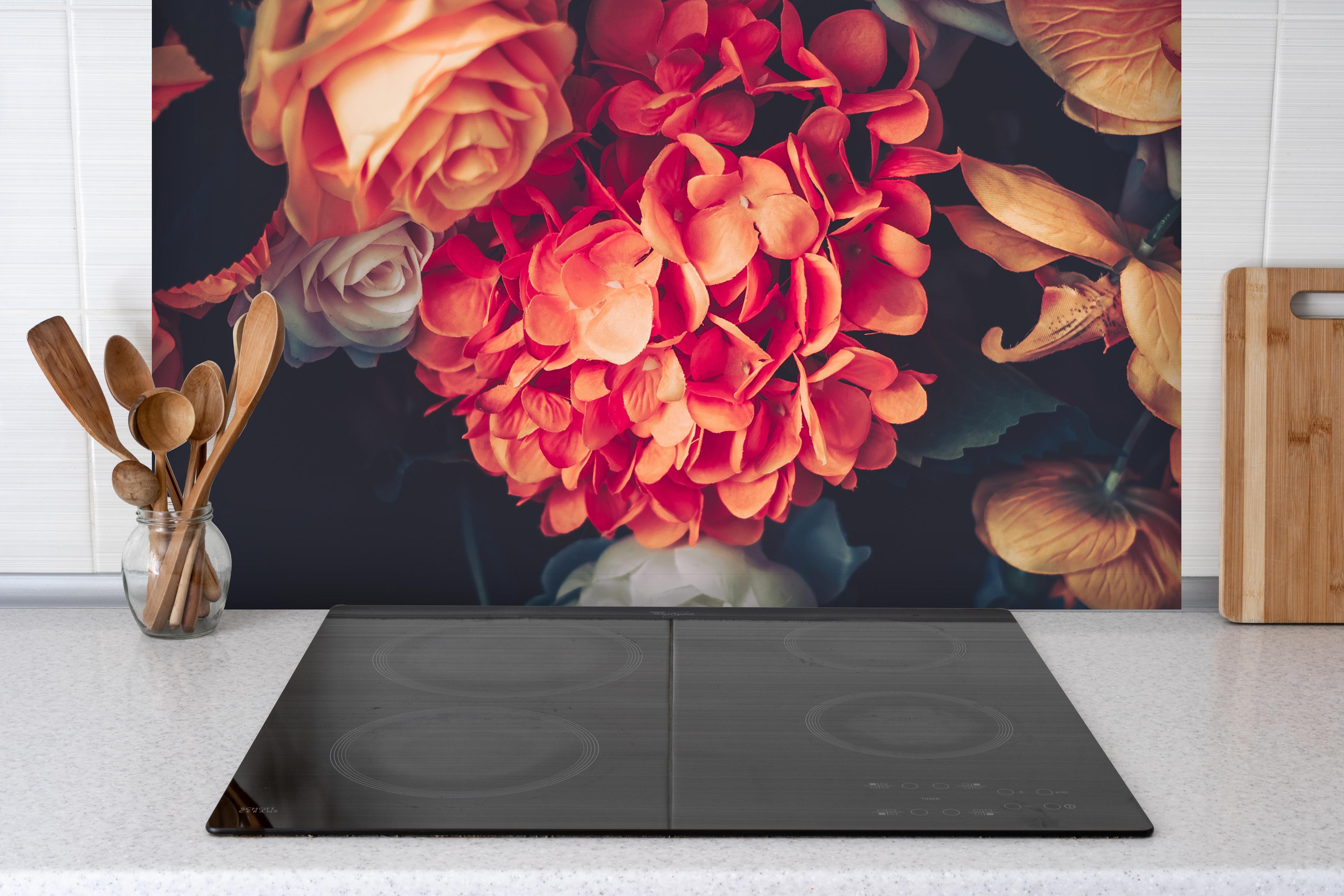 Spritzschutz - Künstliche Blumen im Vintage-Stil - Matt hinter einem Cerankochfeld zwischen Holz-Kochutensilien
