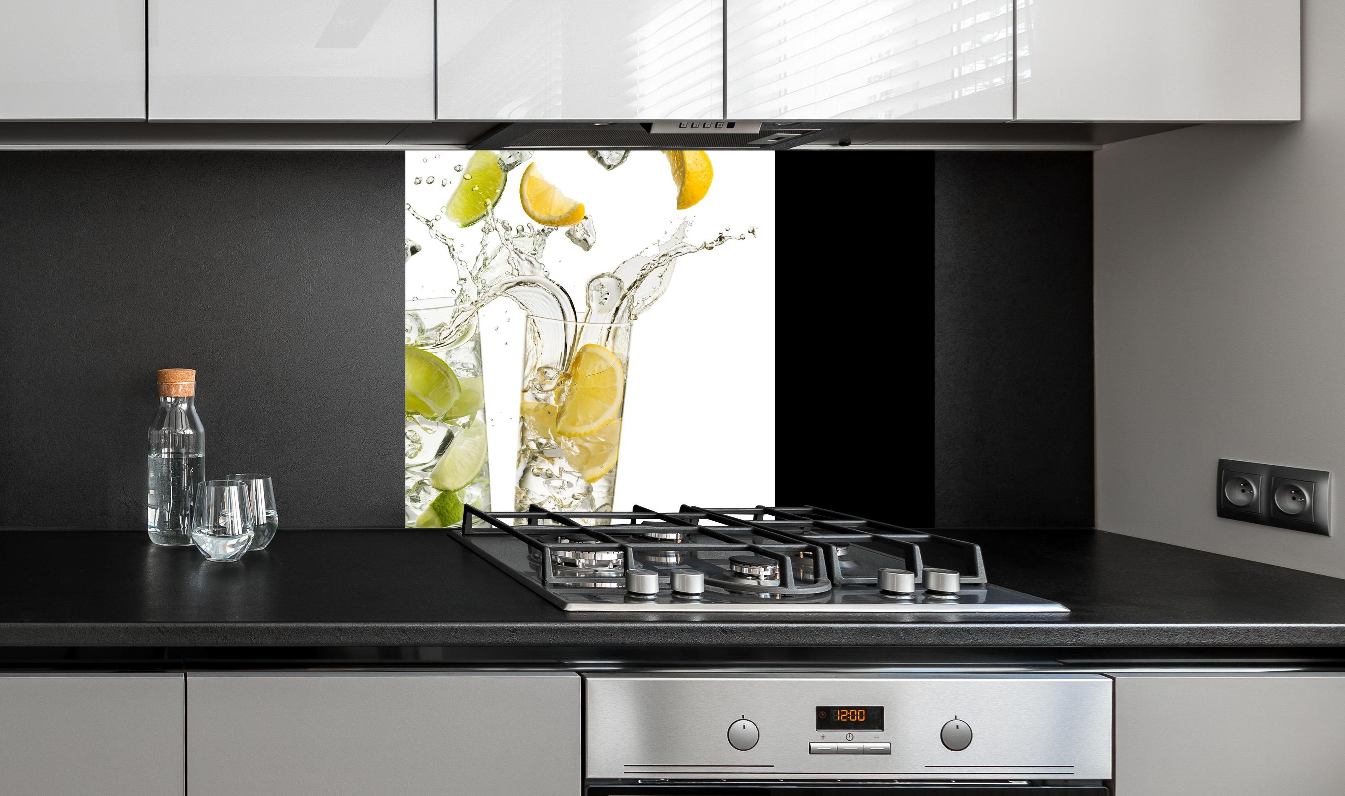 Spritzschutz - Limetten-Zitronen Getränk an edler Anthrazit-Wand hinter silbernem Gasherd