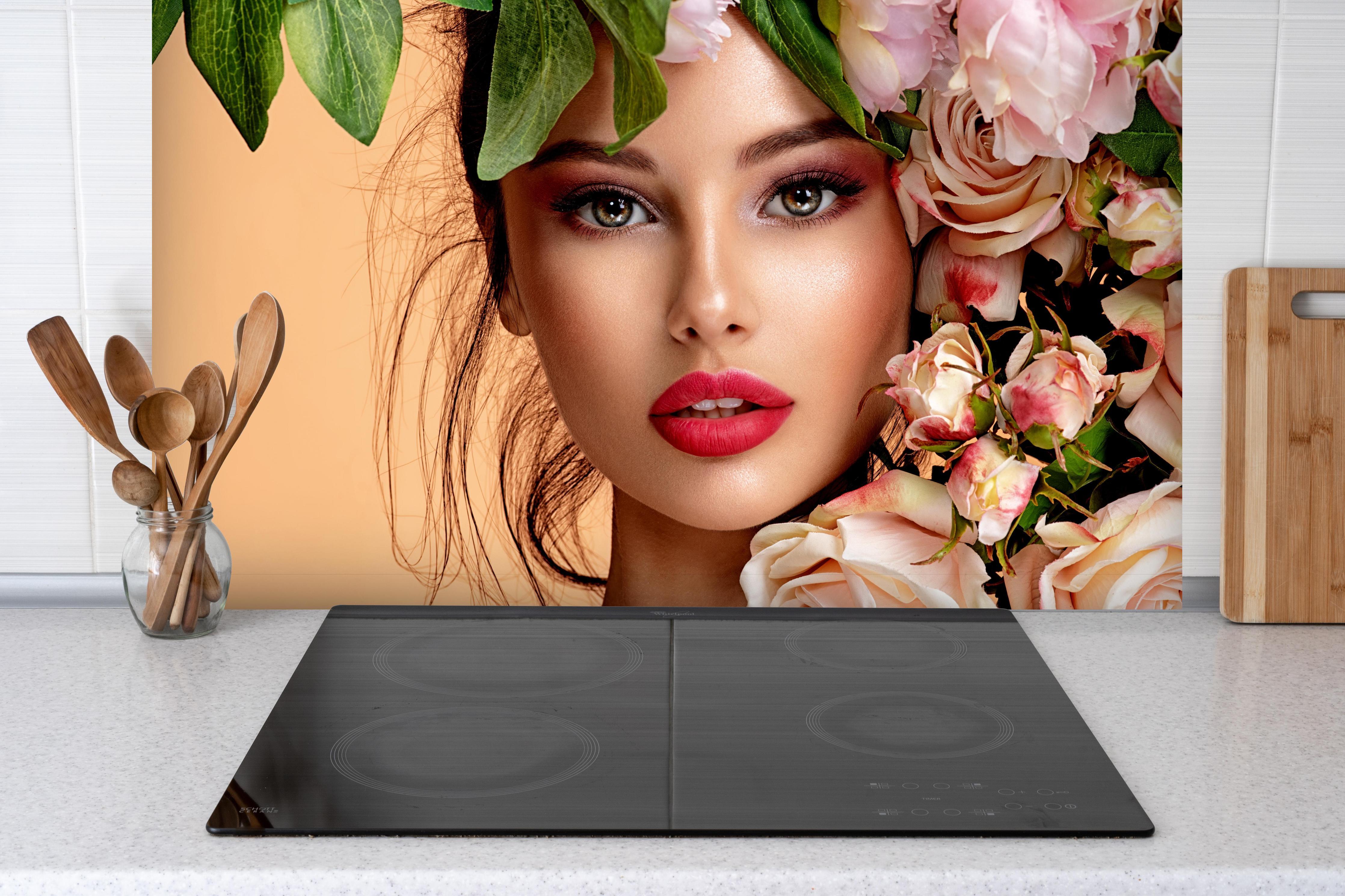 Spritzschutz - Mädchen mit Rosen auf dem Kopf hinter einem Cerankochfeld zwischen Holz-Kochutensilien
