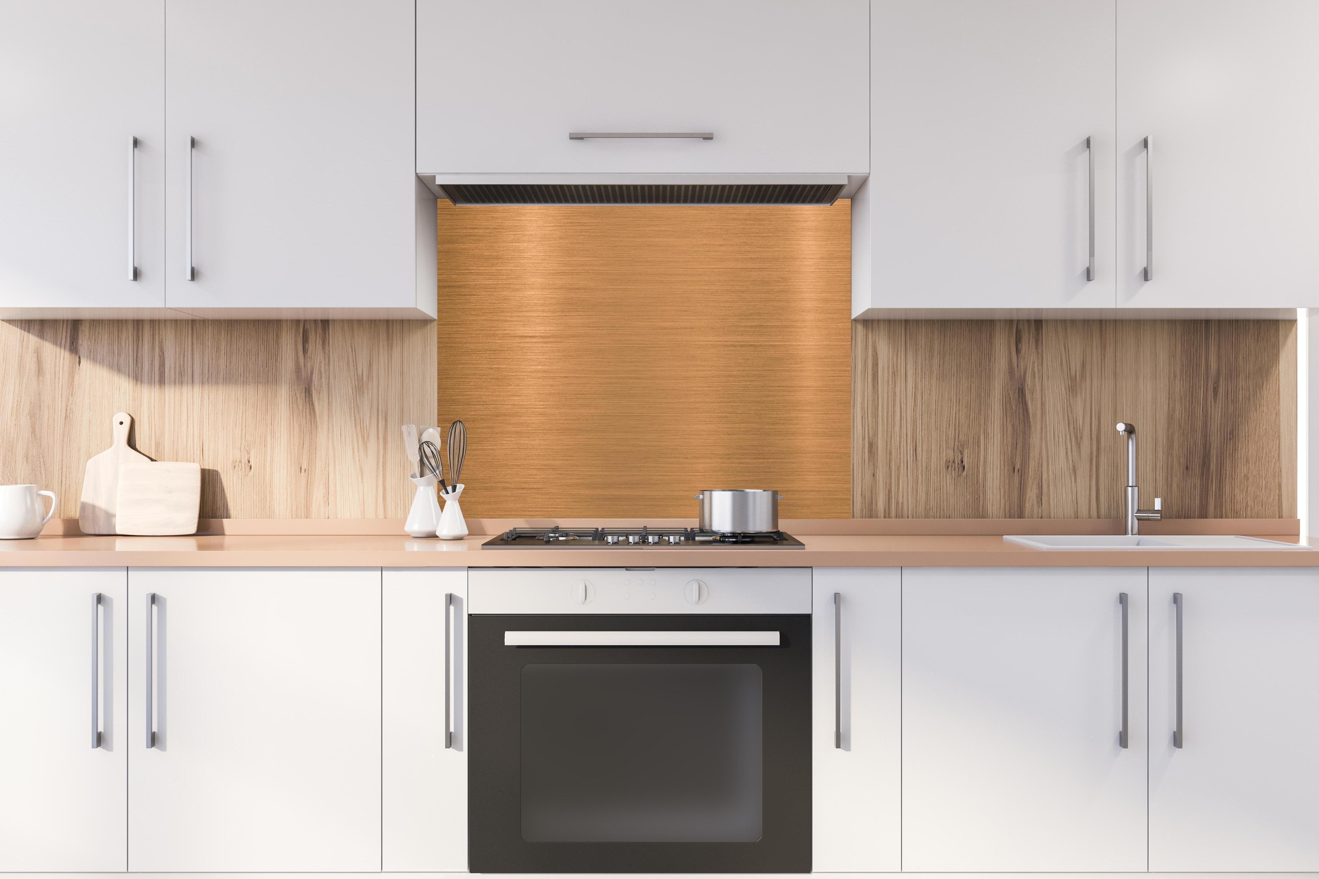 Spritzschutz - Metallische Kupferplatte hinter stilvollem Gasherd unter Dunstabzugshaube