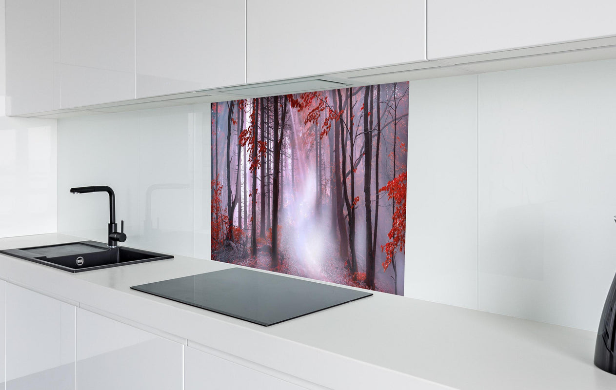 Spritzschutz - Mystischer roter Wald  in weißer Hochglanz-Küche hinter einem Cerankochfeld