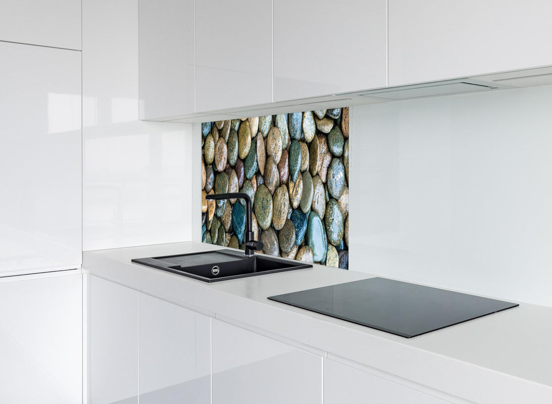 Spritzschutz - Nasse Steine hinter modernem schwarz-matten Spülbecken in weißer Hochglanz-Küche