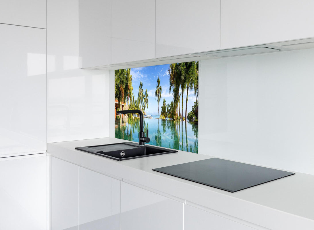 Spritzschutz - Panorama-Pool in der Karibik hinter modernem schwarz-matten Spülbecken in weißer Hochglanz-Küche