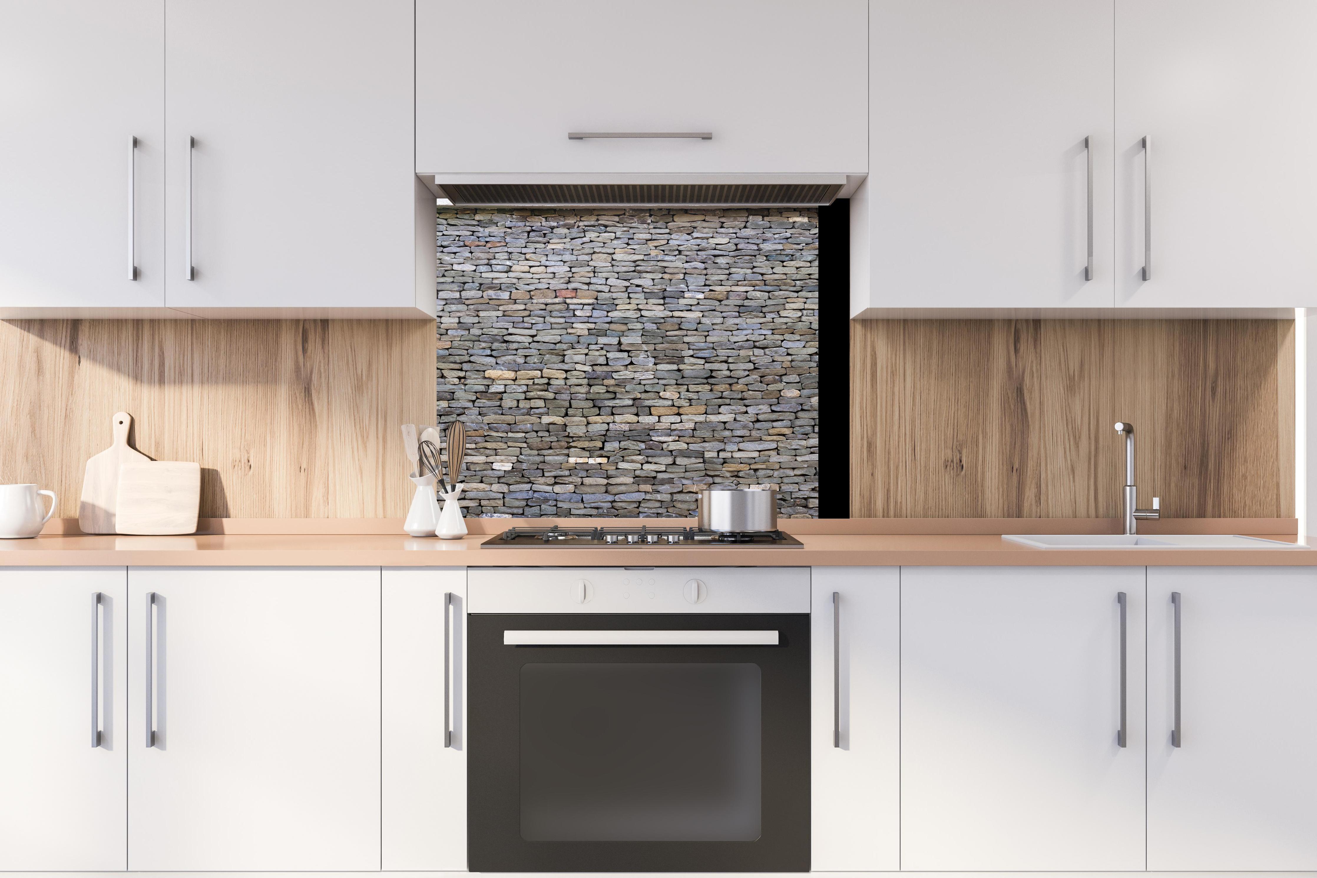 Spritzschutz - Pastellfarbene Steinmauer hinter stilvollem Gasherd unter Dunstabzugshaube