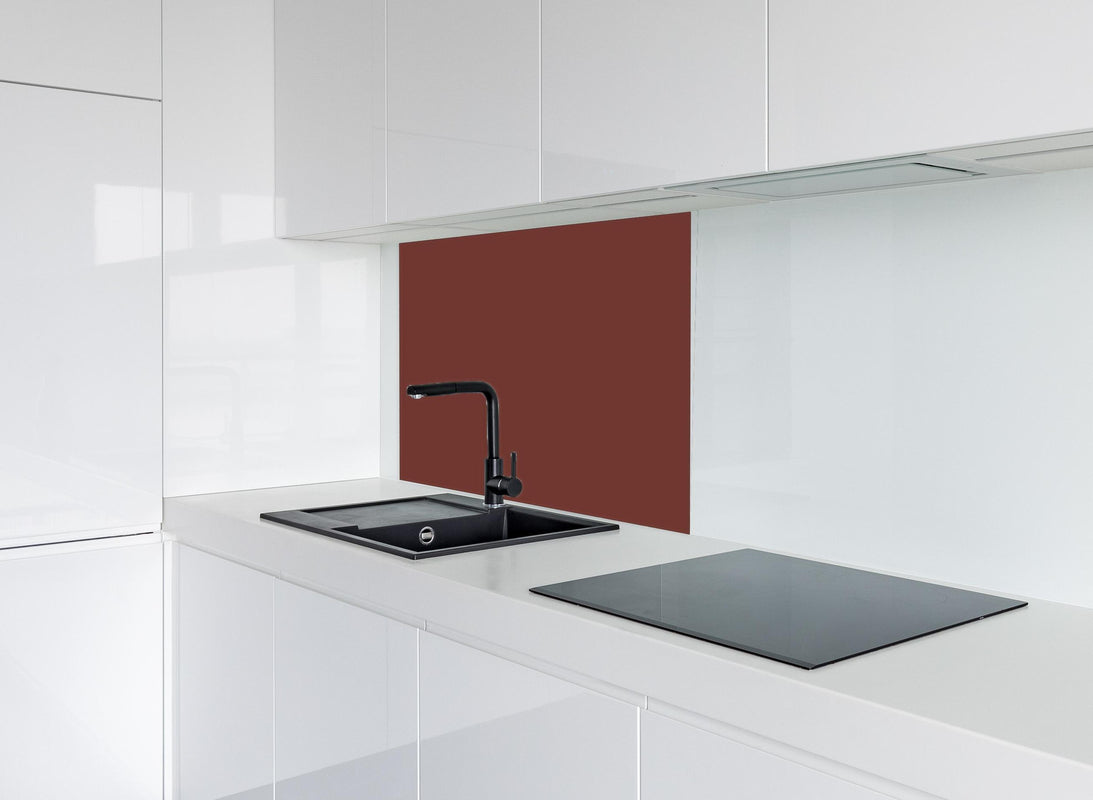 Spritzschutz - RAL 3009 (Oxidrot) hinter modernem schwarz-matten Spülbecken in weißer Hochglanz-Küche