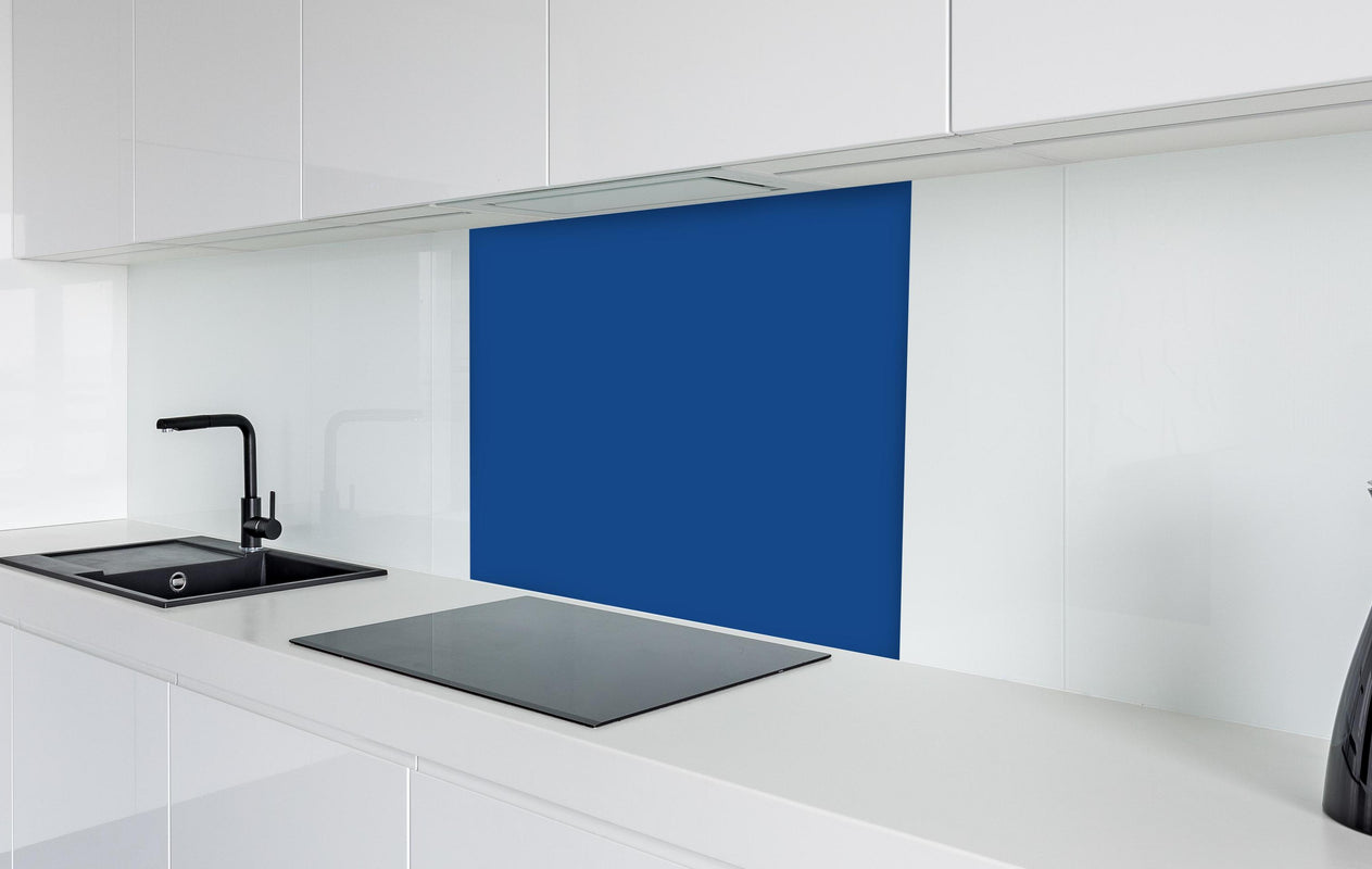 Spritzschutz - RAL 5005 (Signalblau)  in weißer Hochglanz-Küche hinter einem Cerankochfeld