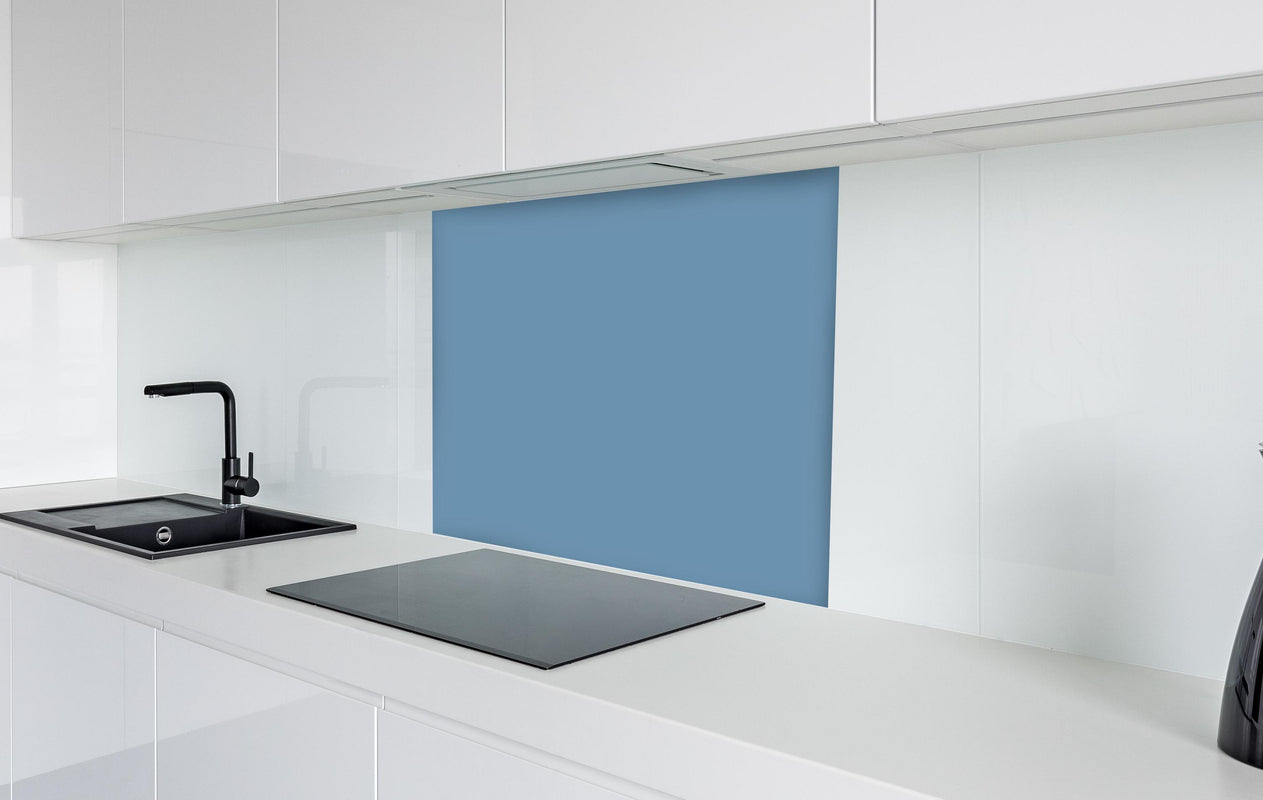 Spritzschutz - RAL 5024 (Pastellblau)  in weißer Hochglanz-Küche hinter einem Cerankochfeld