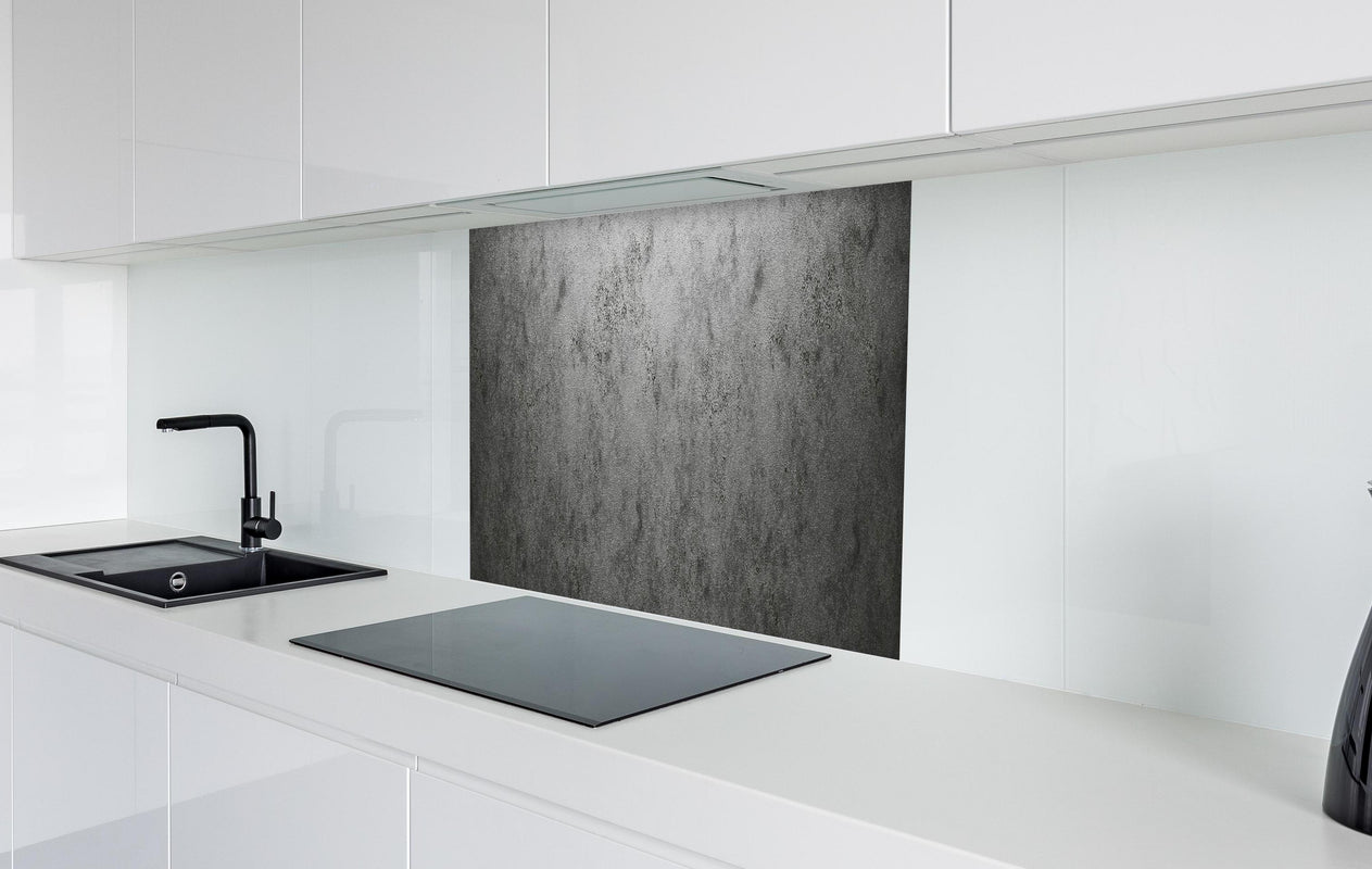 Spritzschutz - Raue metallische Oberfläche  in weißer Hochglanz-Küche hinter einem Cerankochfeld