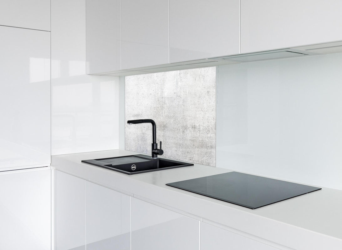 Spritzschutz - Rauer weißer Beton hinter modernem schwarz-matten Spülbecken in weißer Hochglanz-Küche