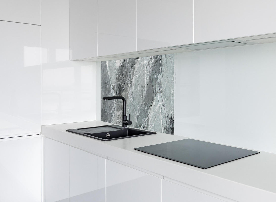 Spritzschutz - Rissiger gräulicher Marmor  hinter modernem schwarz-matten Spülbecken in weißer Hochglanz-Küche